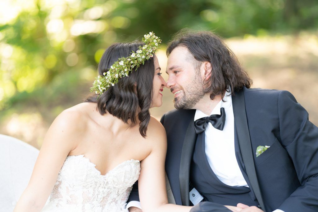 Romantic moment captured in an outdoor garden setting with elegant formal attire.