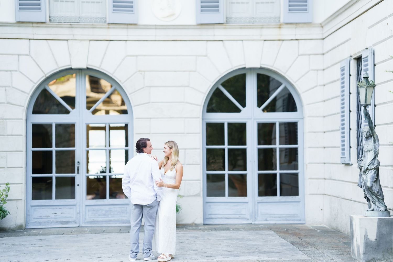 White marble building exterior with arched windows and columns creates a grand architectural facade.