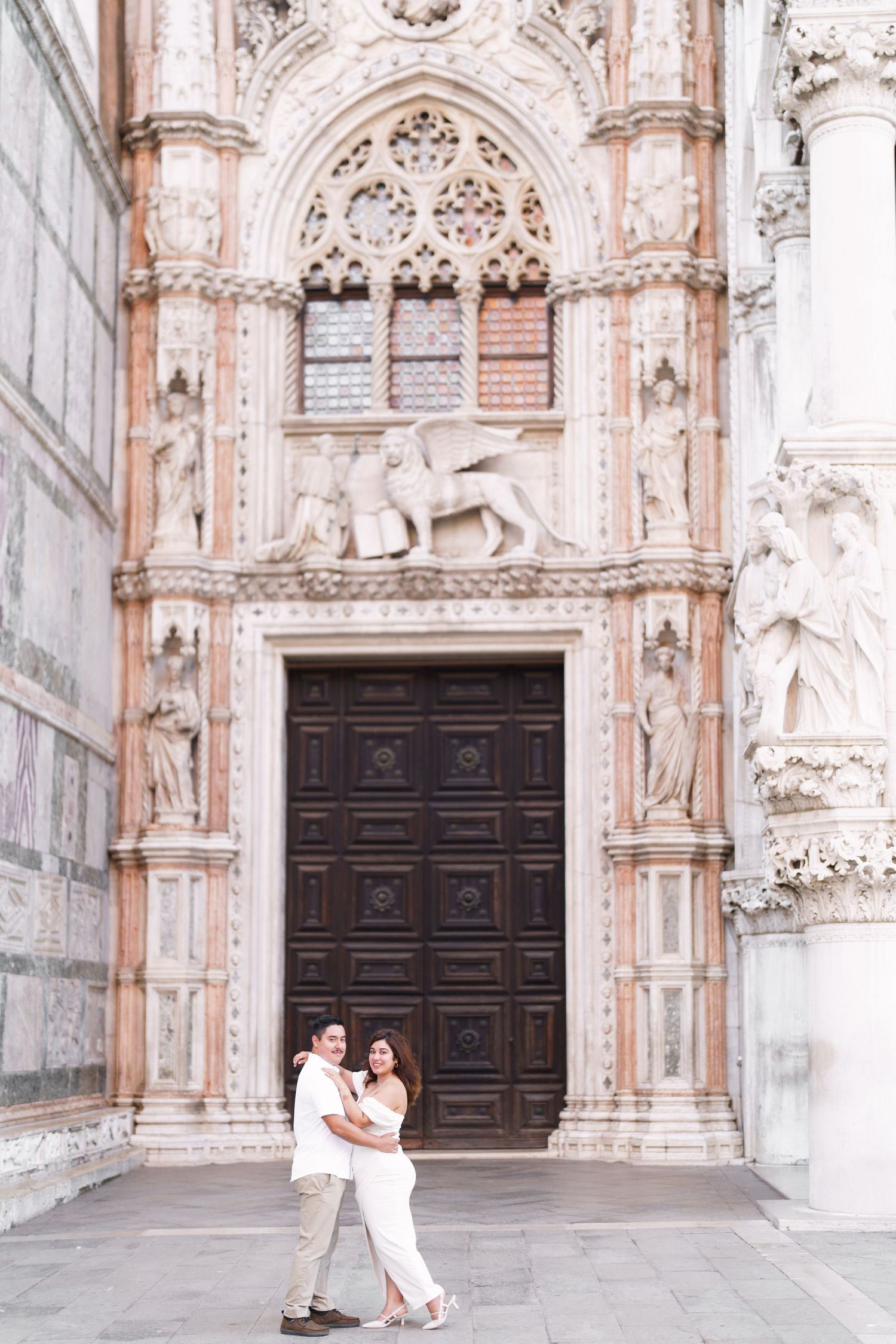 A series of romantic photos taken at a grand cathedral entrance with ornate Gothic architecture and stone carvings.