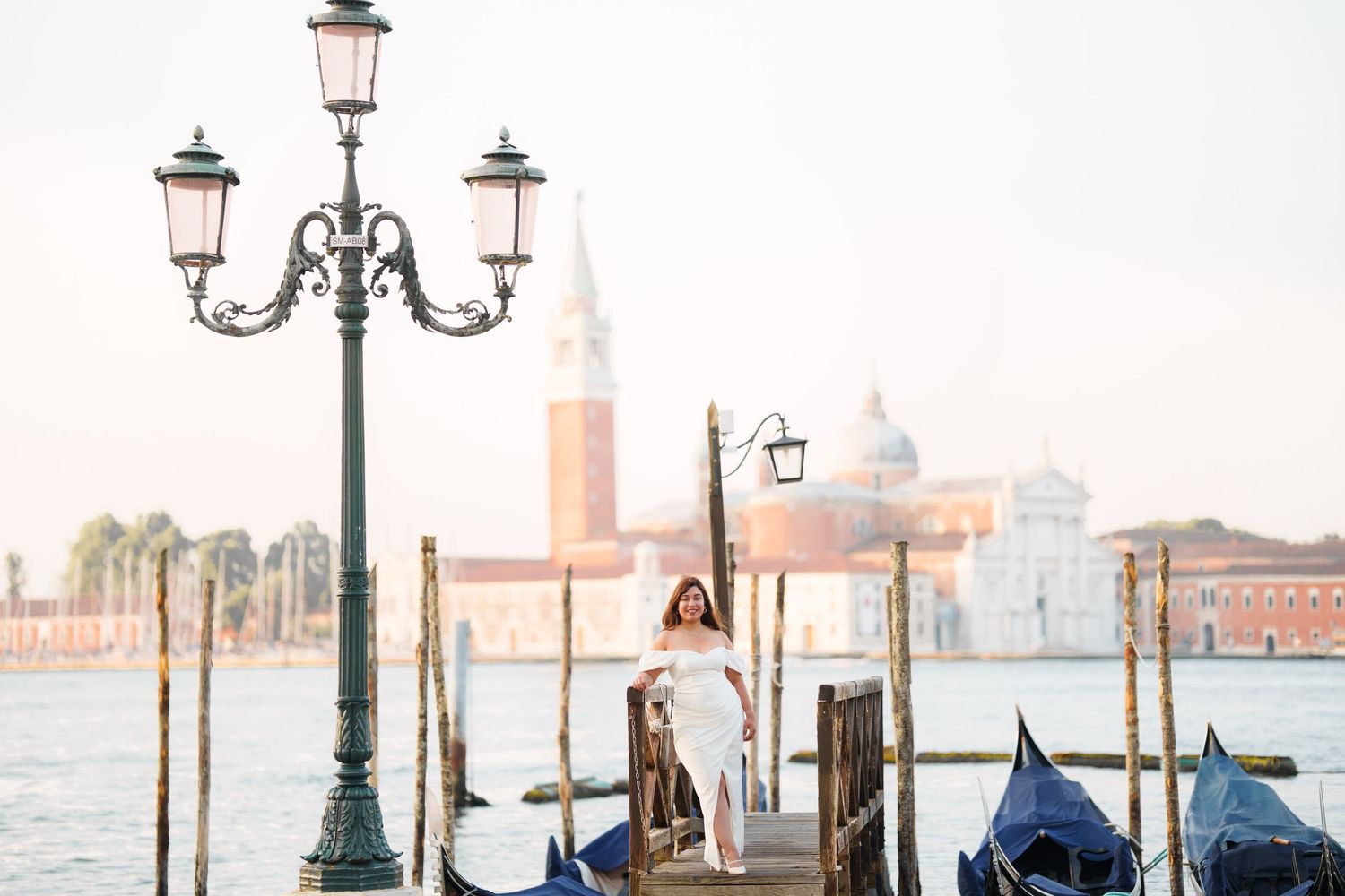 photographer venice Scenic view of Venice's Grand Canal with ornate lampposts, gondolas, and historic buildings in soft morning light.