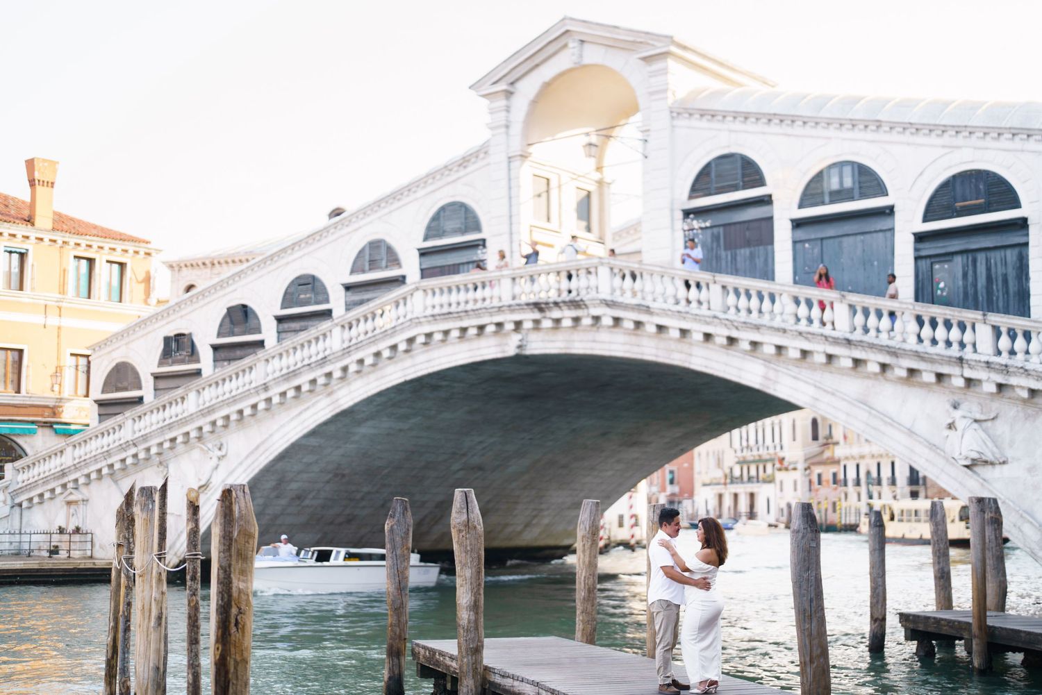 photographer venice The iconic Rialto Bridge spans across Venice's Grand Canal with its white stone arches and elegant architecture.