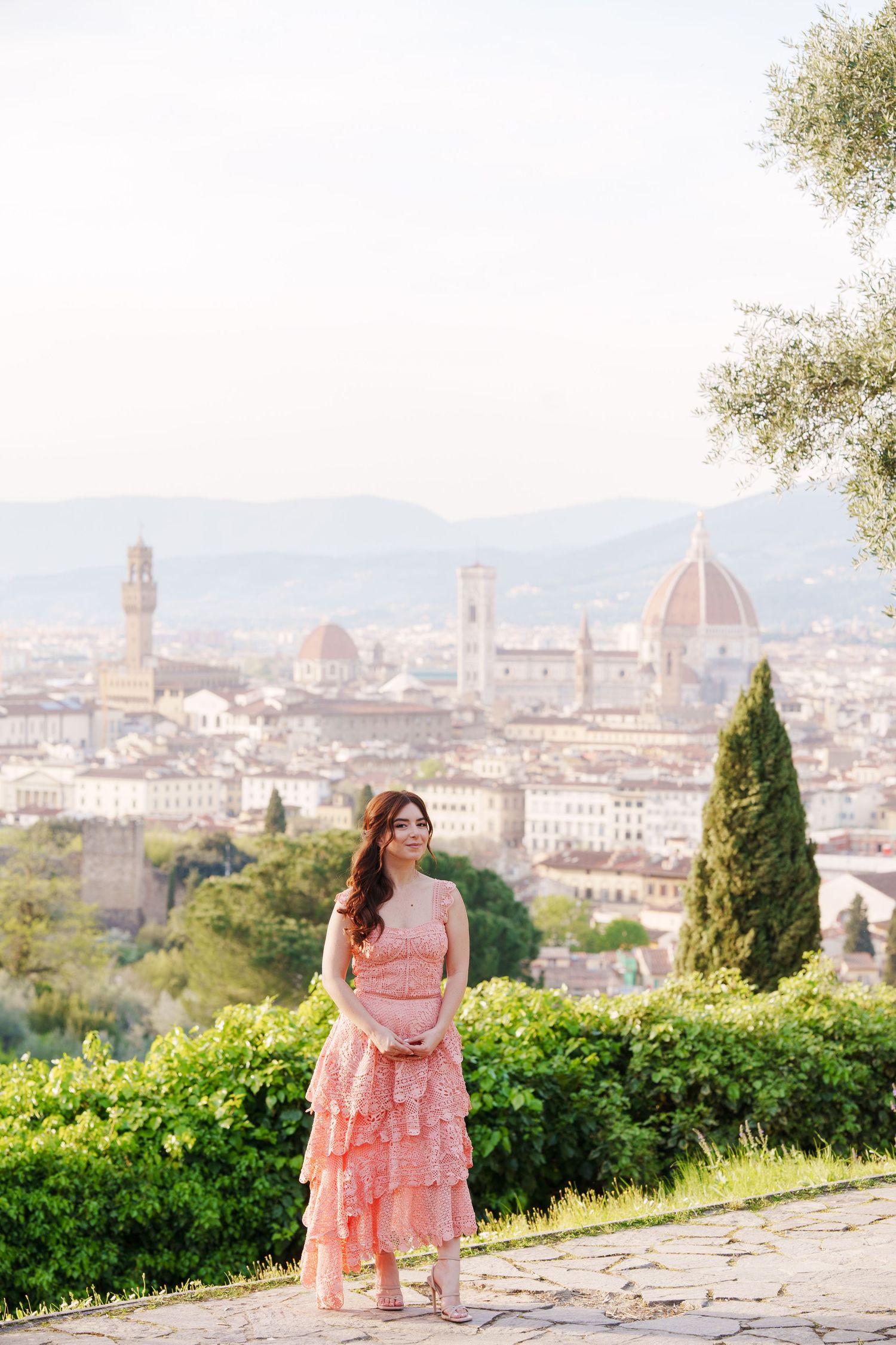 A scenic view of Florence's historic skyline with the Duomo cathedral visible from a hilltop garden terrace.