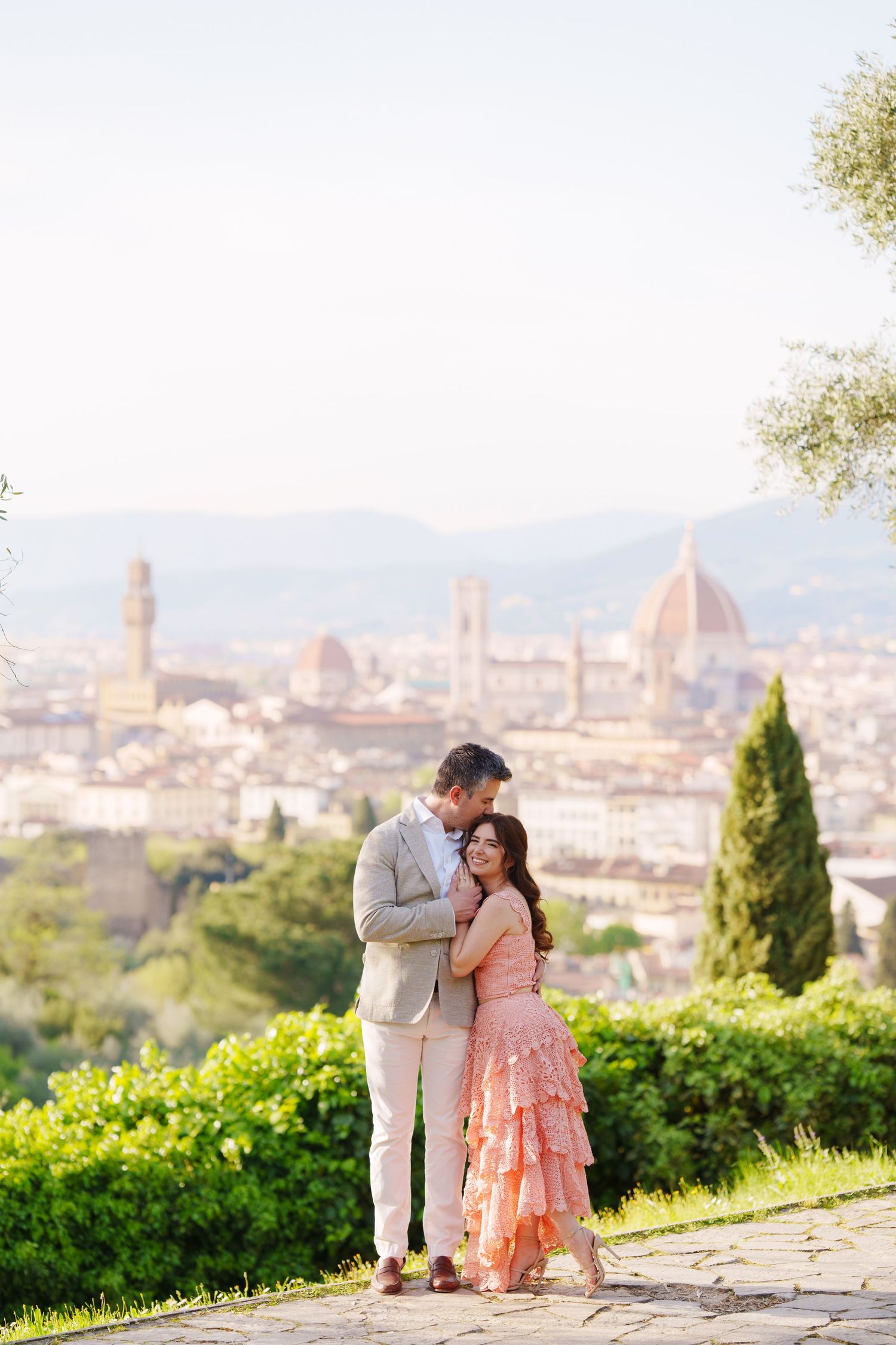 A romantic moment overlooking the historic skyline of Florence, Italy with the Duomo cathedral visible in the background.