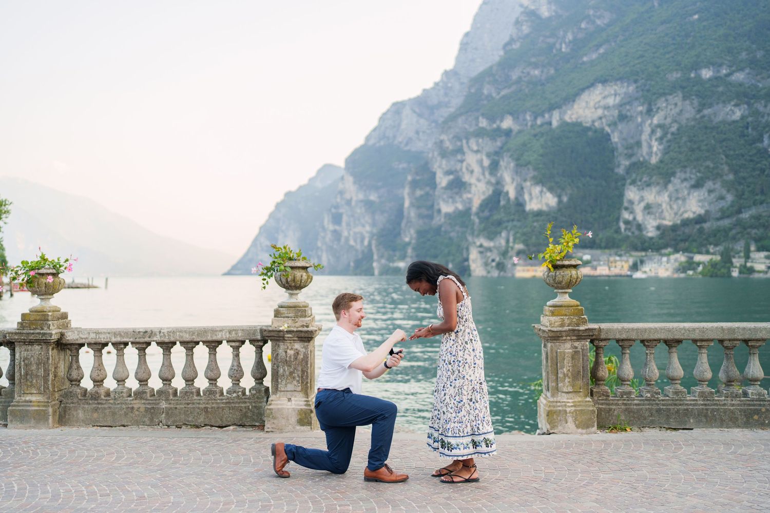 Engaged couple embracing beside Lake Garda during their Riva del Garda proposal session