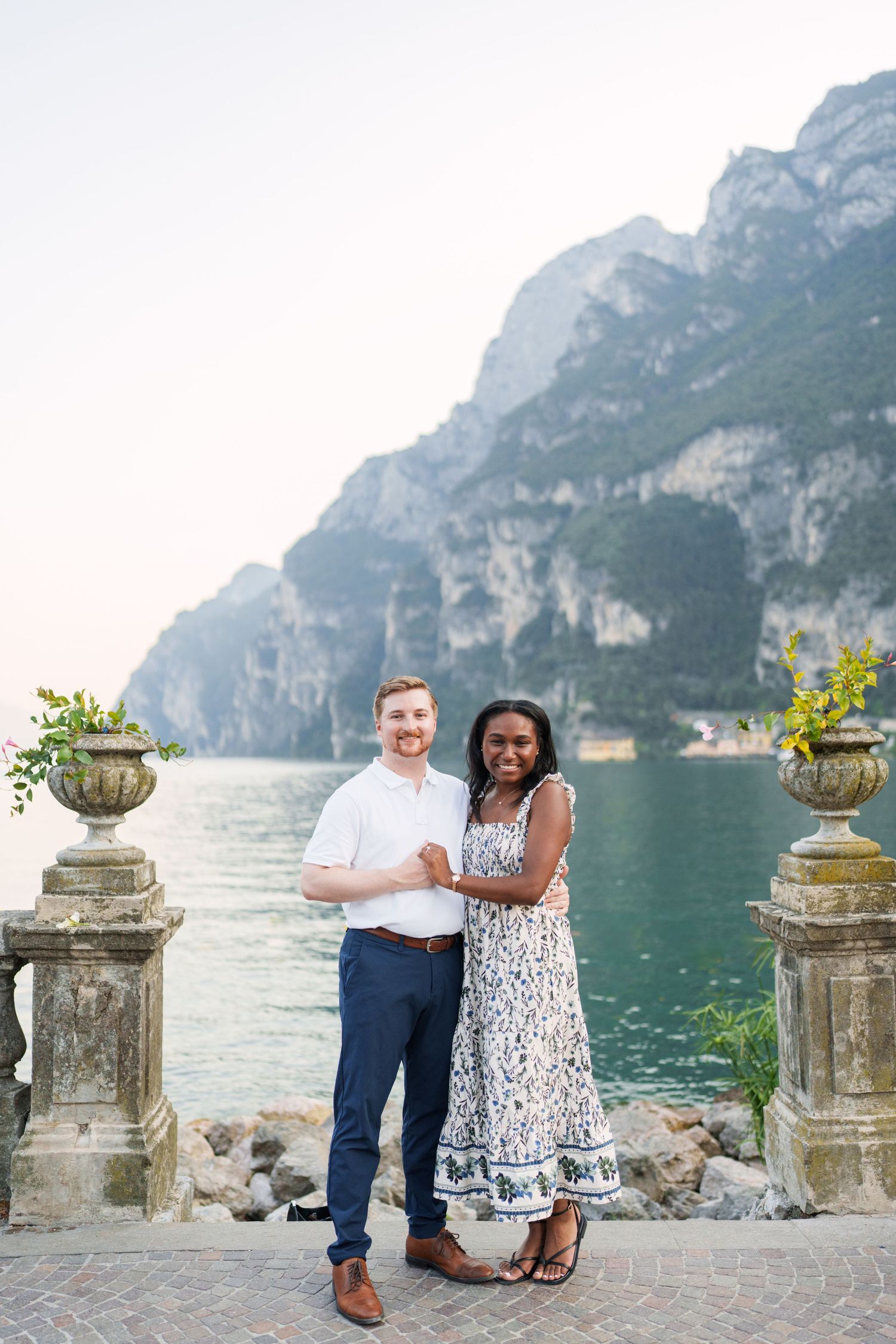 Engaged couple embracing beside Lake Garda during their Riva del Garda proposal session