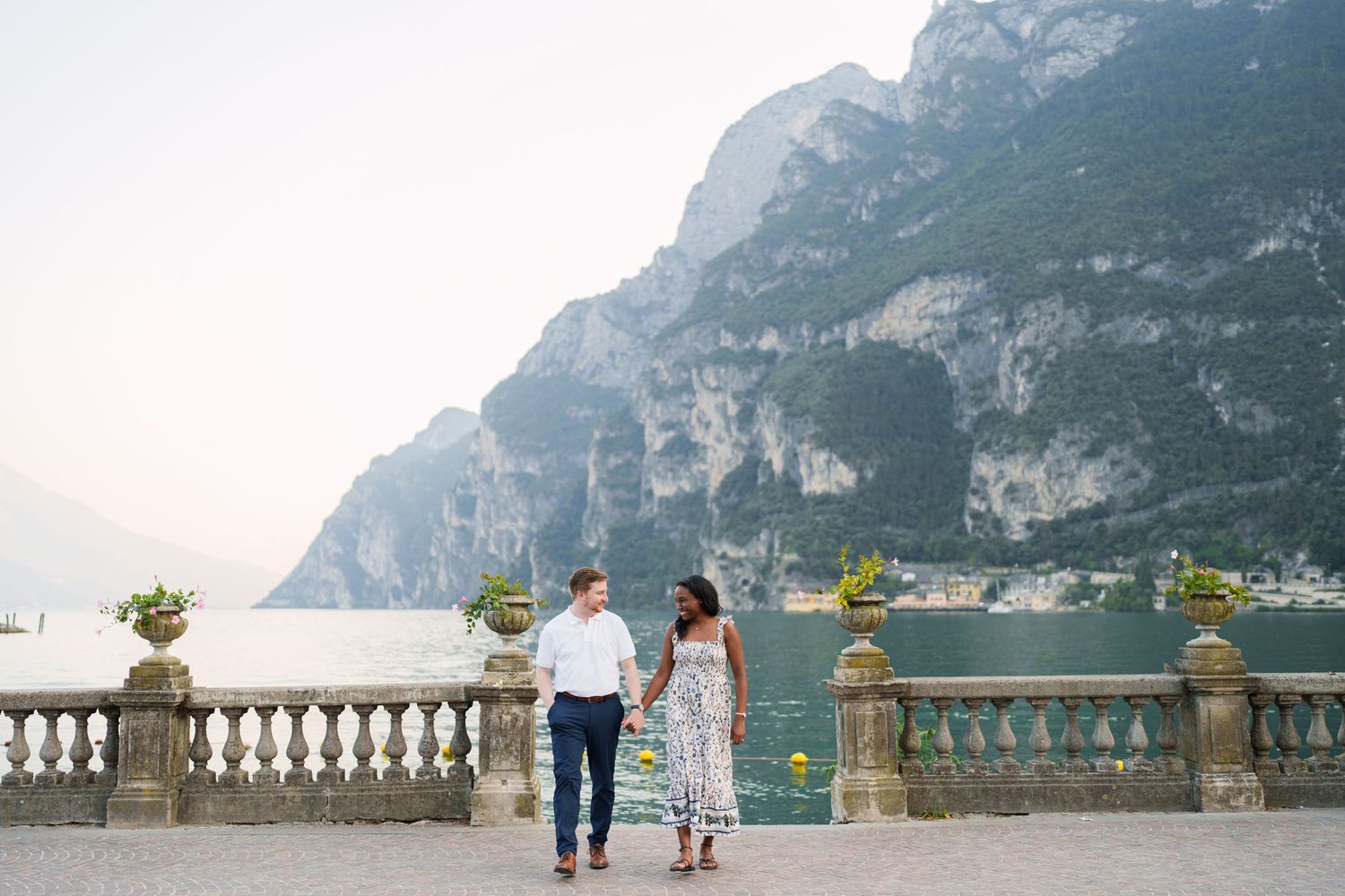 Engaged couple embracing beside Lake Garda during their Riva del Garda proposal session
