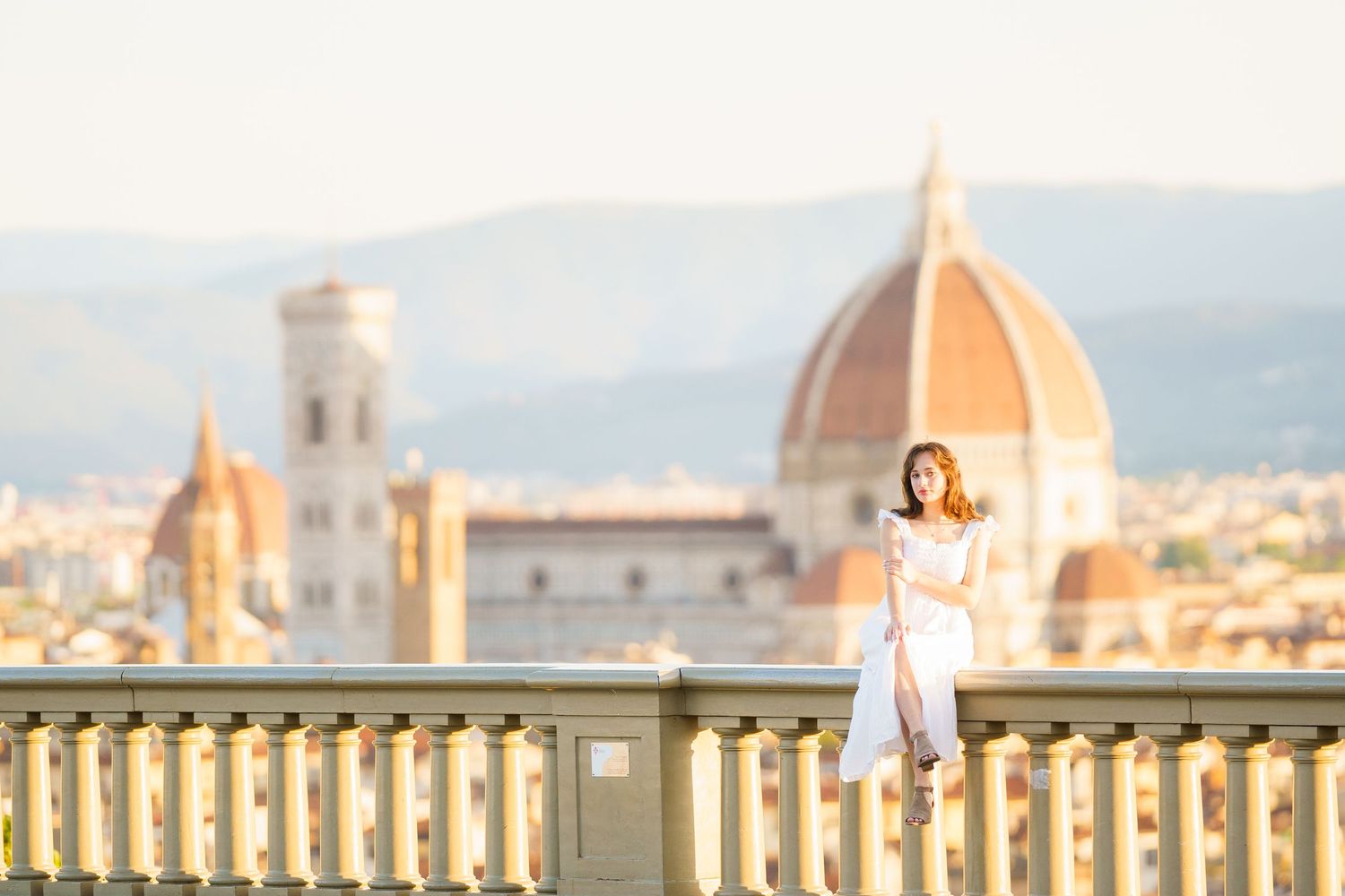The iconic skyline of Florence, Italy features the historic Duomo cathedral dome against a soft sunset sky.