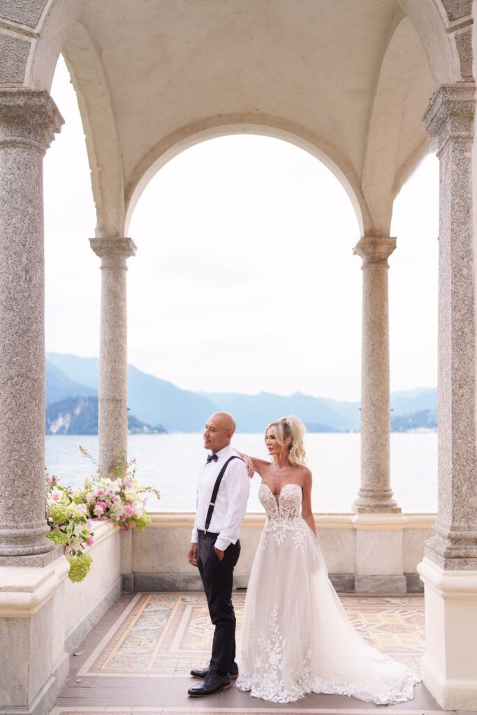 Romantic colonnade with arched walkway overlooking Lake Como and mountains in Italy.