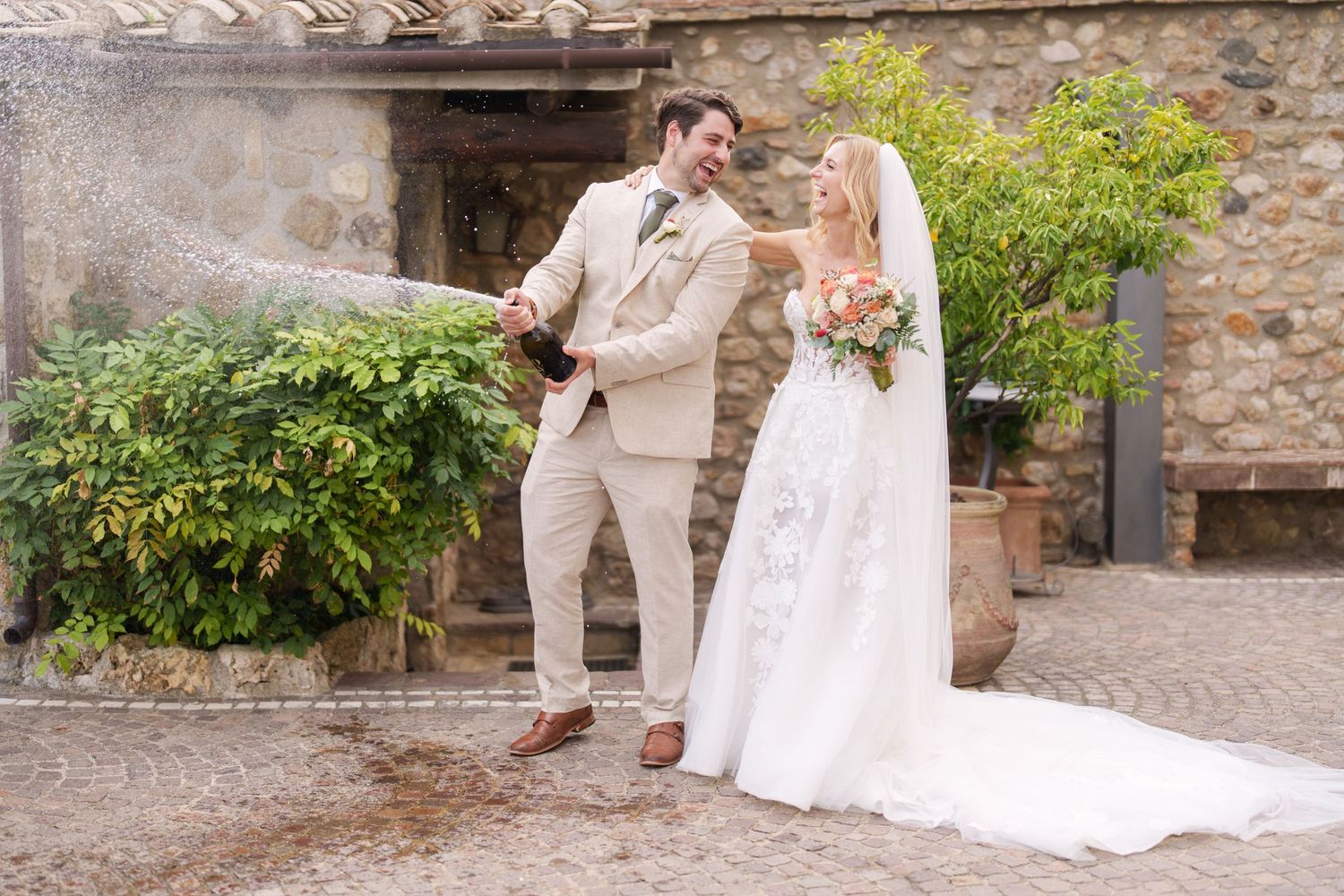 Wedding couple walking and posing along a rustic stone pathway in an outdoor setting.