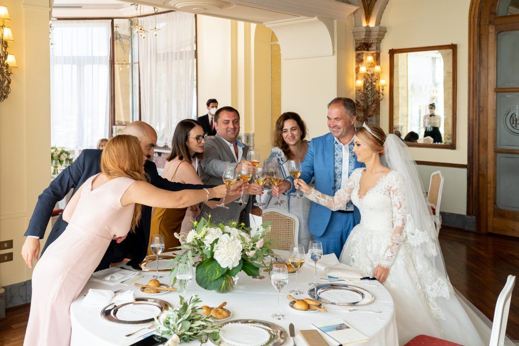 Wedding reception dining setup with white tablecloths and floral centerpieces in an elegant ballroom.