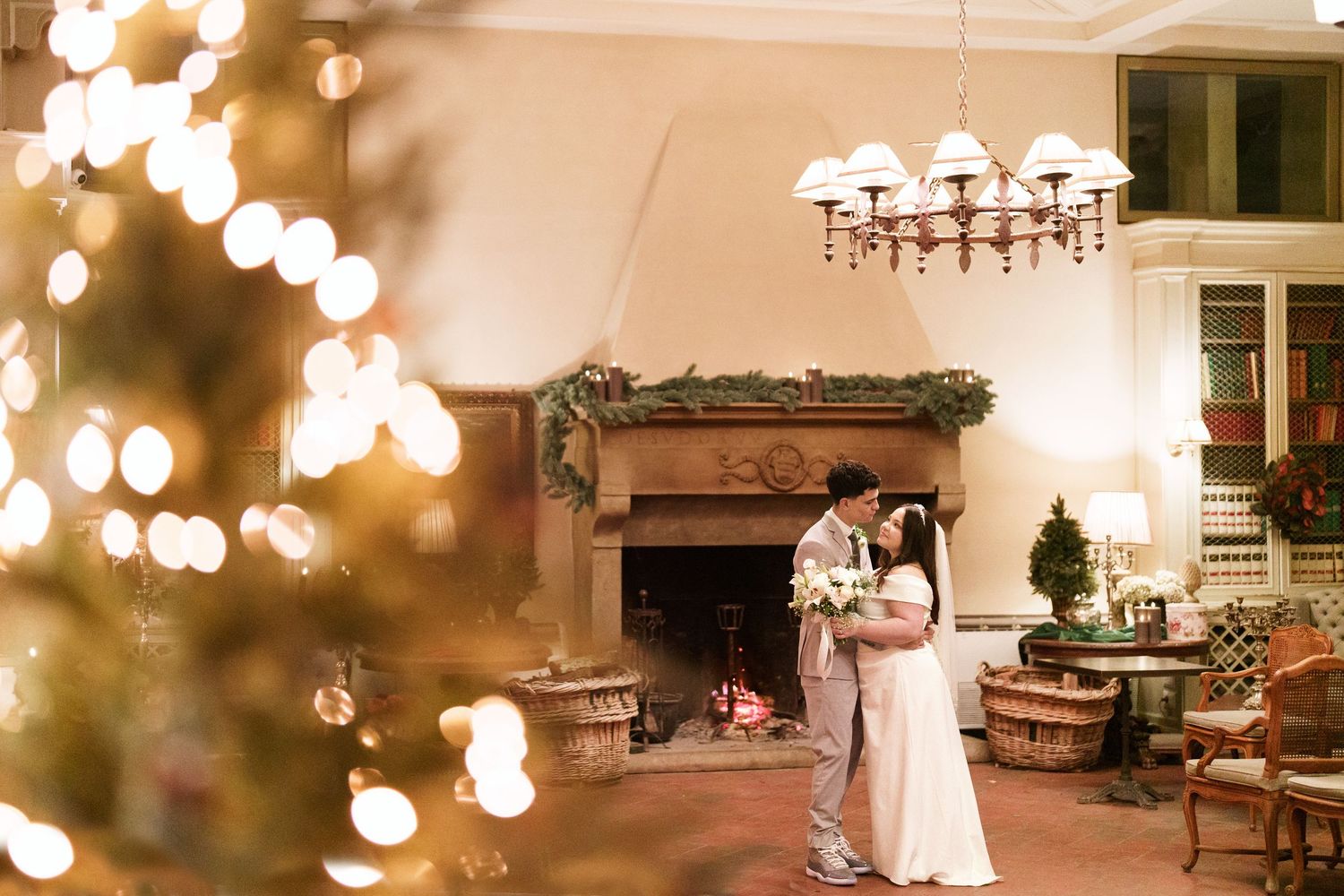 Wedding reception space decorated with warm glowing string lights and elegant chandeliers.