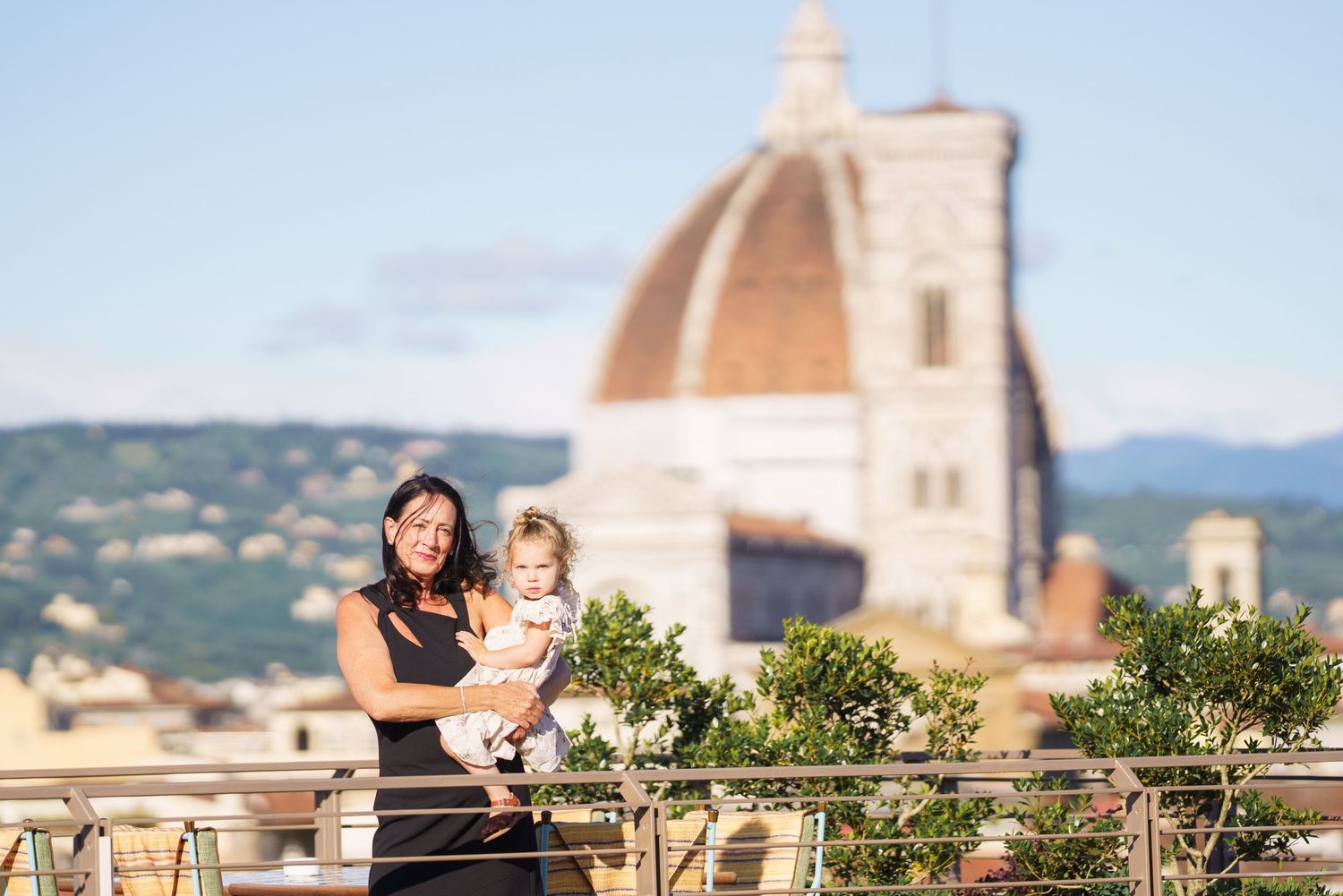 Couple posing on a terrace with Florence's iconic Duomo and historic architecture in view.