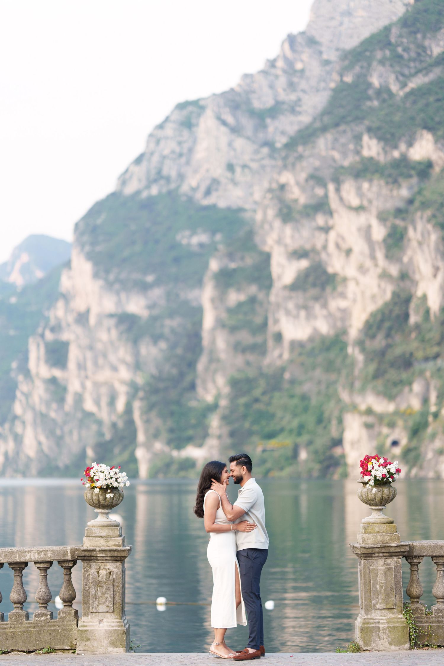 A romantic lakeside scene with mountains and stone balustrades along Lake Garda in Italy.