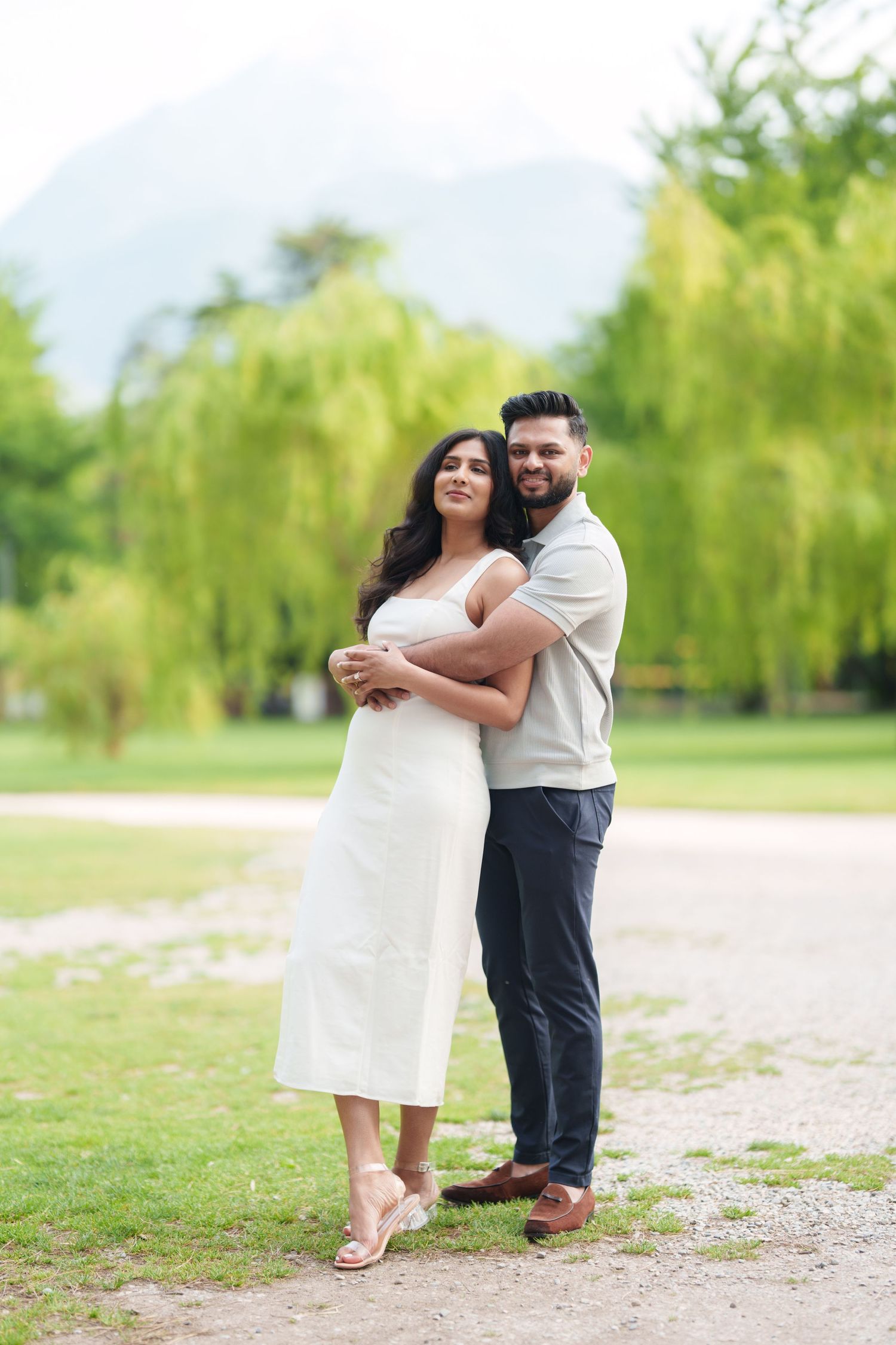 A romantic outdoor engagement photo sequence showing a couple embracing in a park with lush green trees in the background.