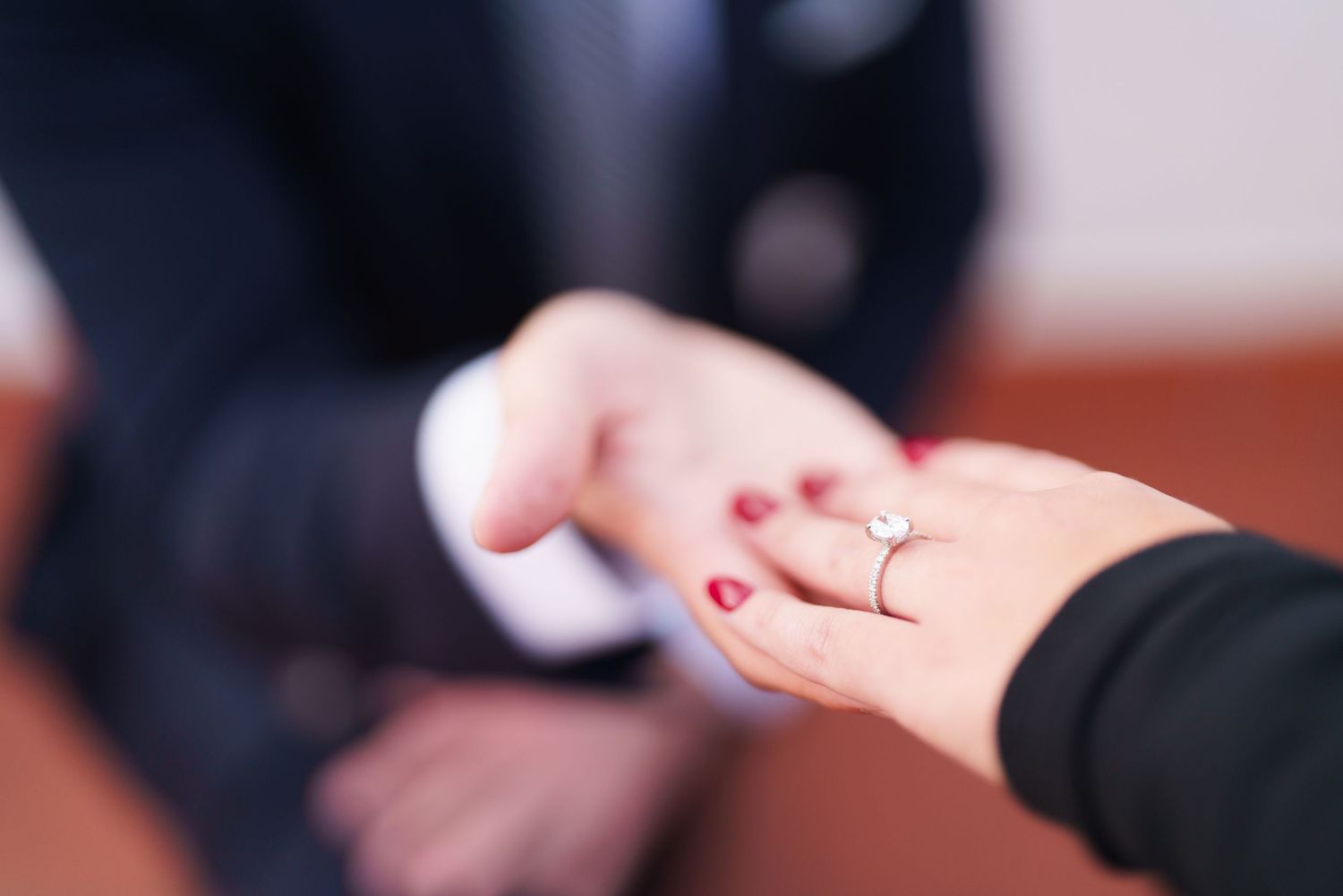 A close-up of hands exchanging wedding rings during an elegant marriage ceremony.