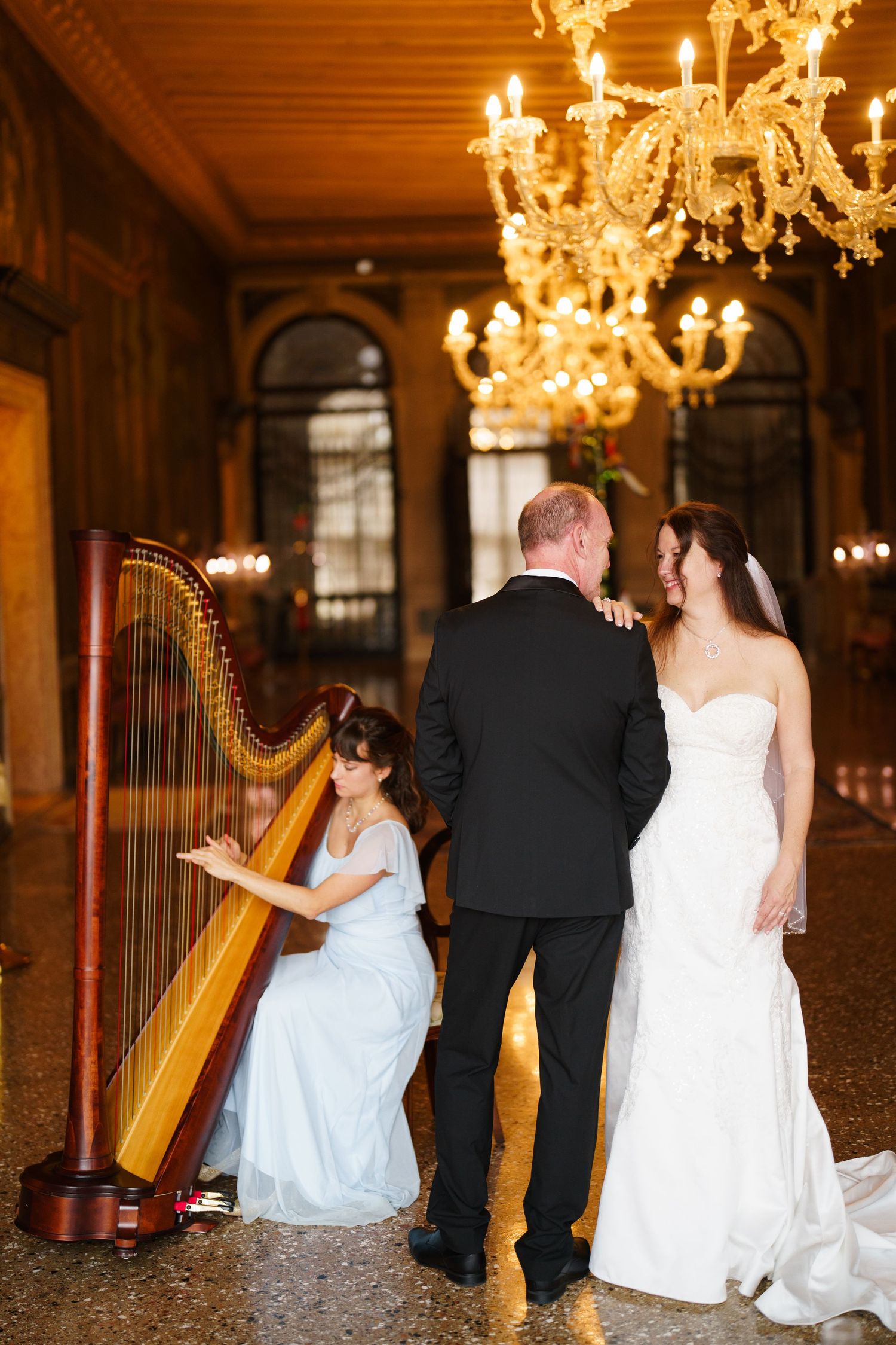 A series of romantic wedding photos showing a couple and a harpist in an elegant ballroom with crystal chandeliers.