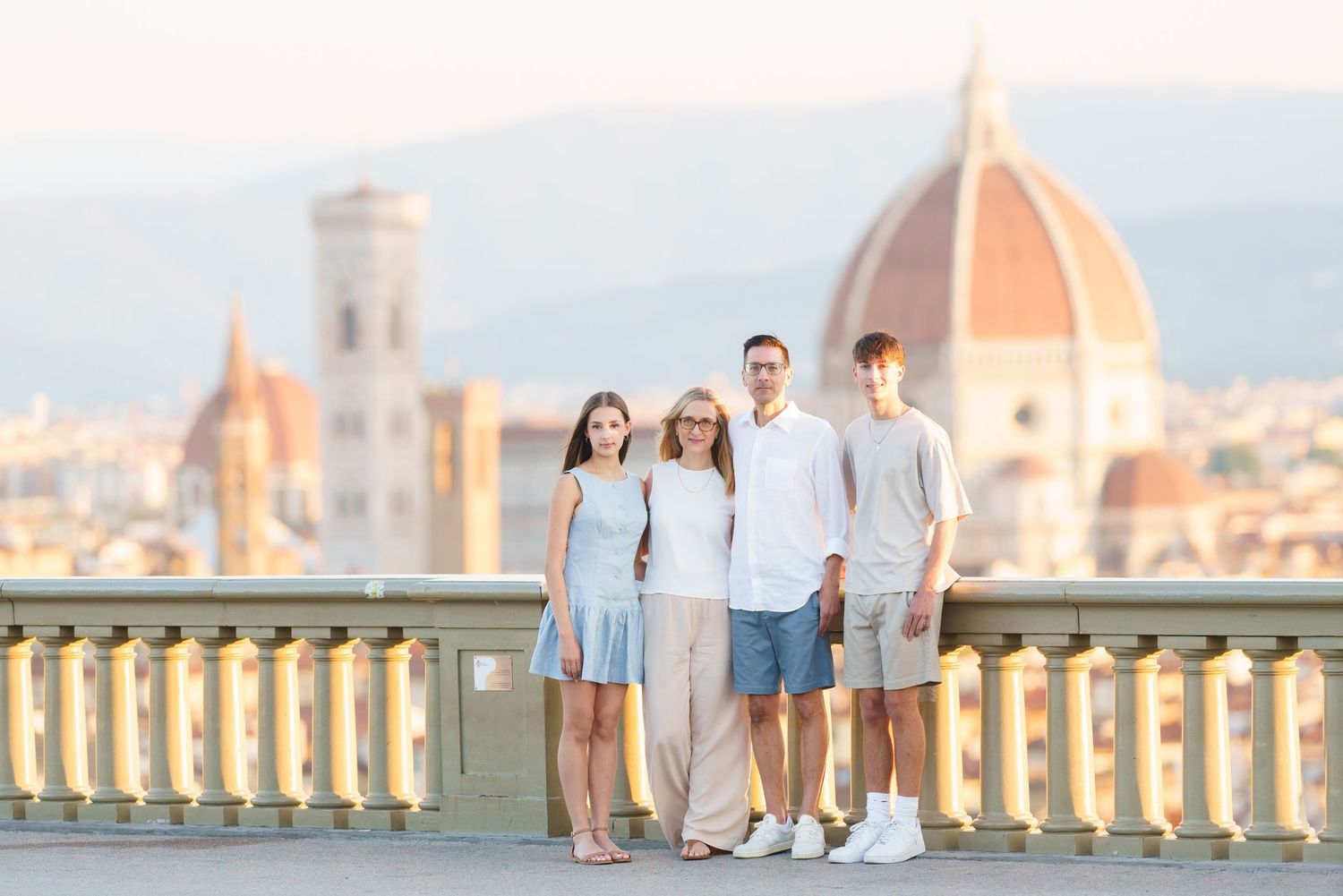 photographer Florence A family walks along Piazzale Michelangelo in Florence with the iconic Duomo cathedral visible in the background.