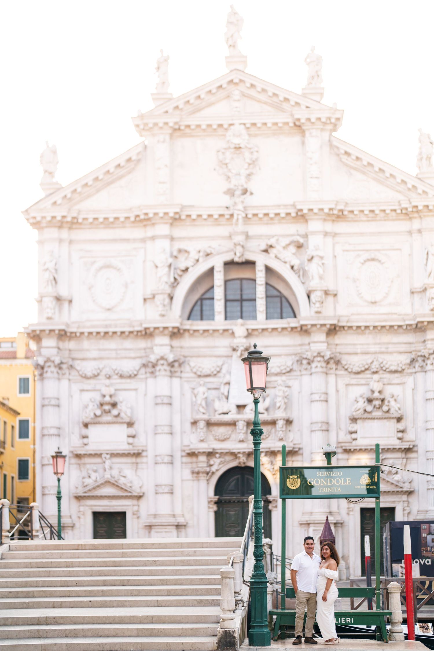 A grand white baroque church facade with ornate architectural details and stone steps leading to its entrance.