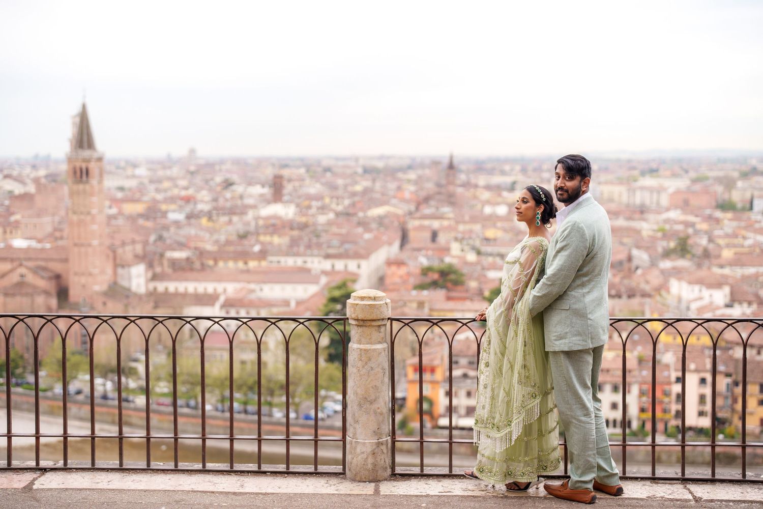 Romantic couple admires panoramic cityscape view of Madrid from elevated viewpoint at sunset.
