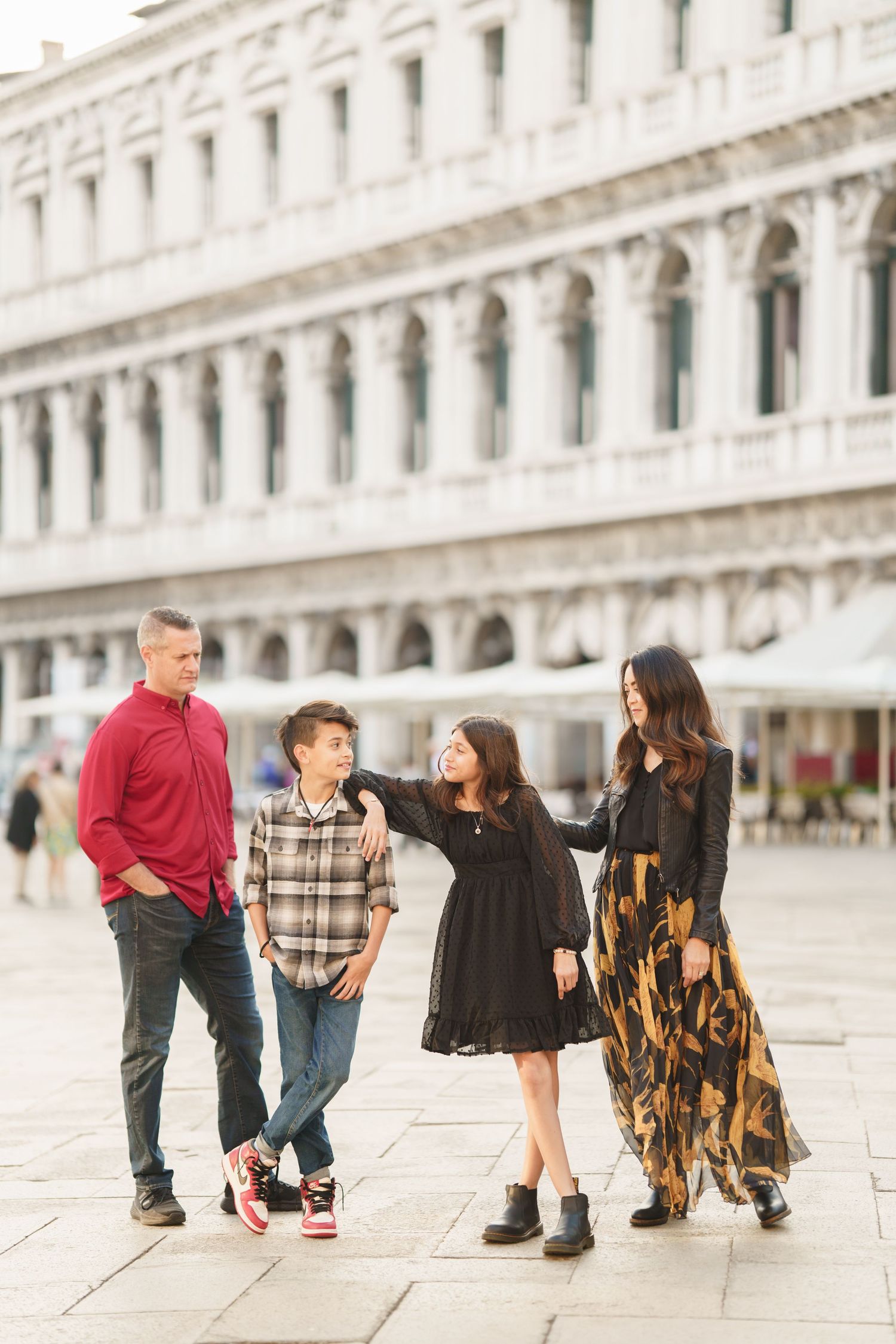 A family sits together on white stone steps in Venice's St. Mark's Square, captured in a series of connected photos.
