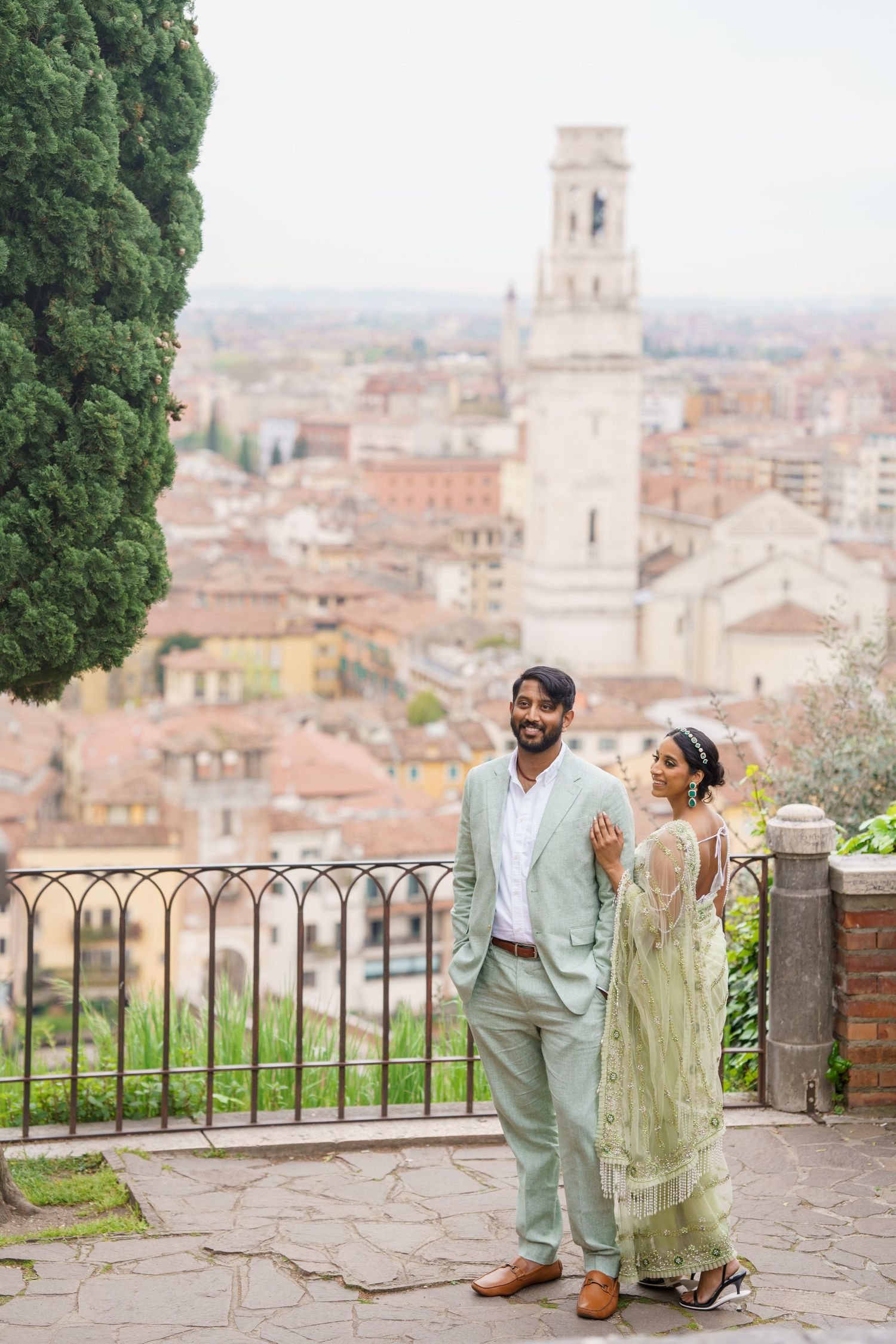 A couple enjoys a romantic moment overlooking the historic cityscape of Florence, Italy from a scenic viewpoint.