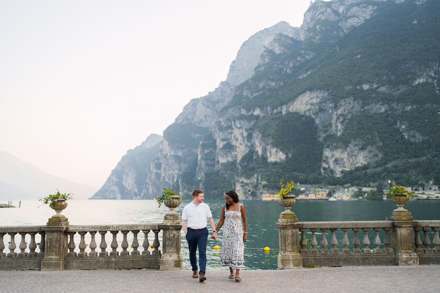 Engaged couple embracing beside Lake Garda during their Riva del Garda proposal session