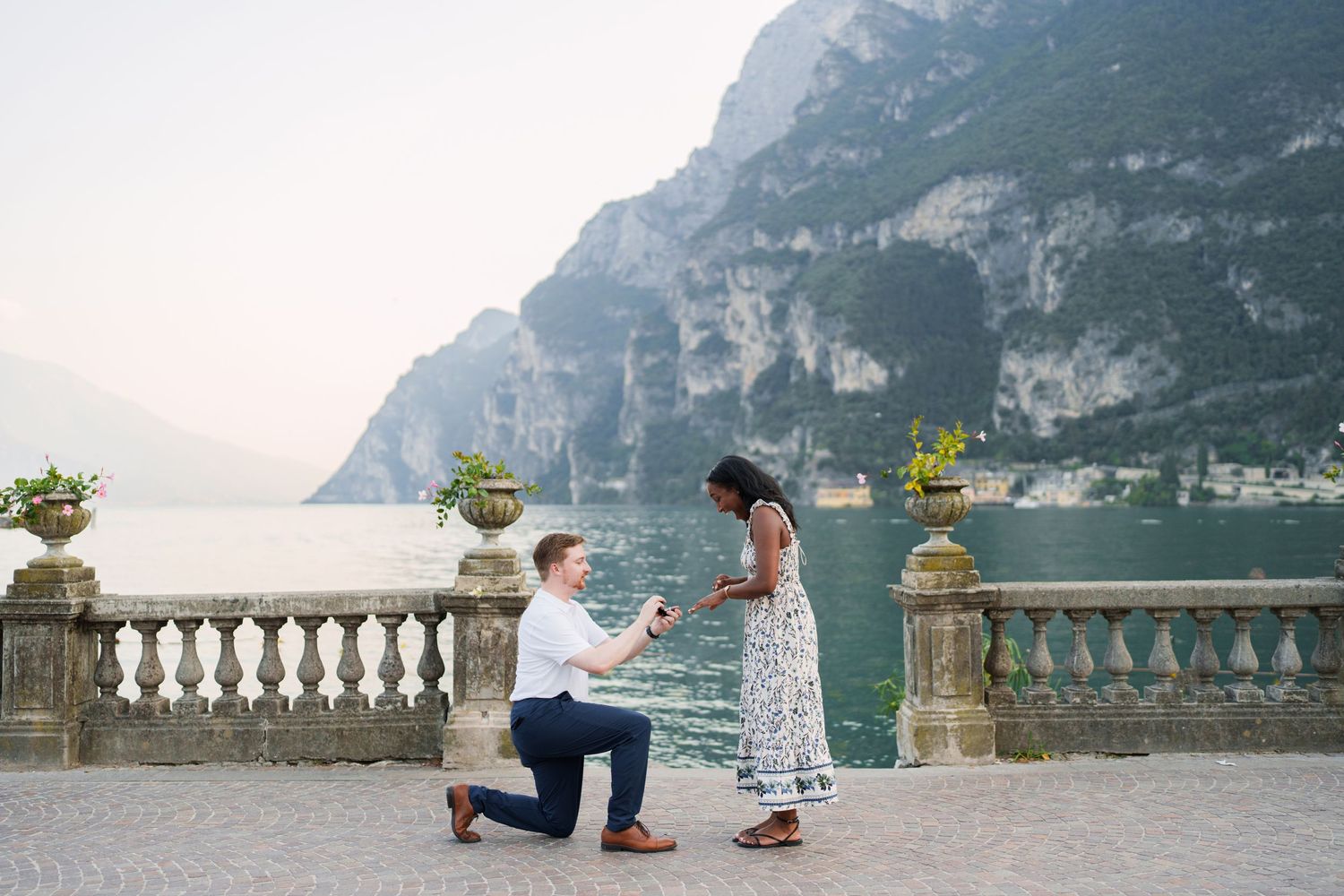 Couple walking together along the waterfront after their proposal in Riva del Garda