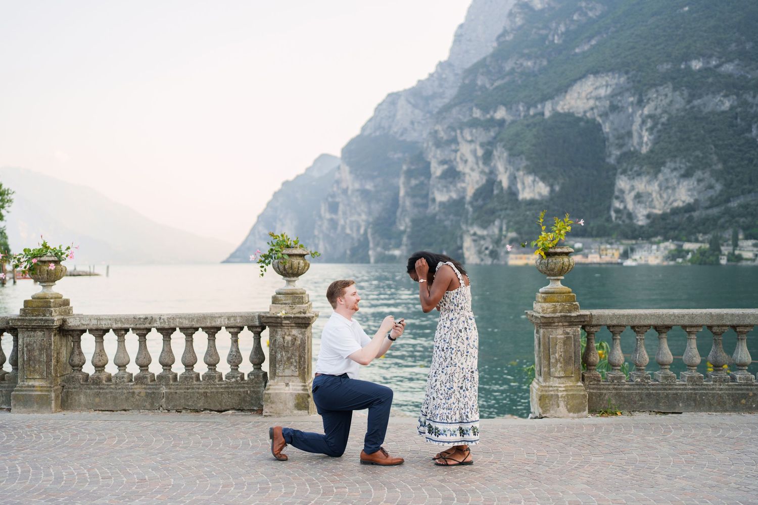 Engaged couple embracing beside Lake Garda during their Riva del Garda proposal session