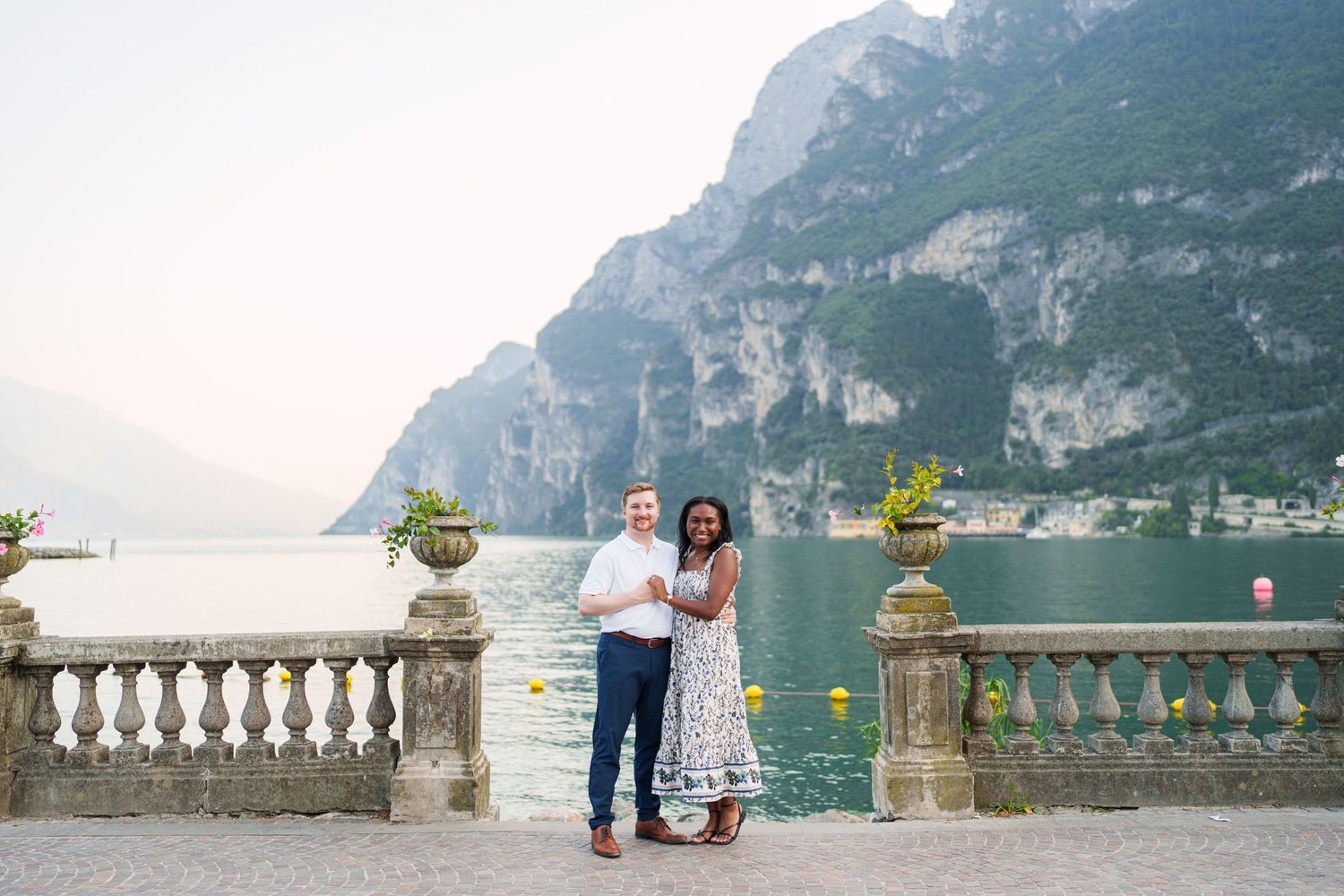 Engaged couple embracing beside Lake Garda during their Riva del Garda proposal session