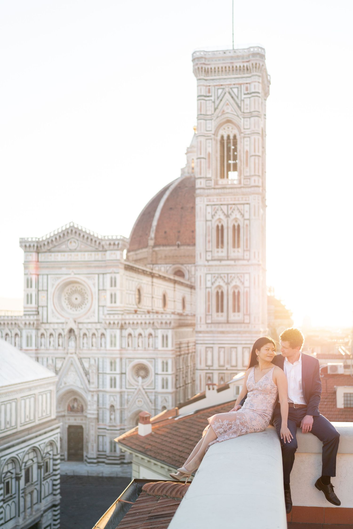 Romantic wedding couple embraces at sunset in front of the historic Florence Cathedral in Italy.