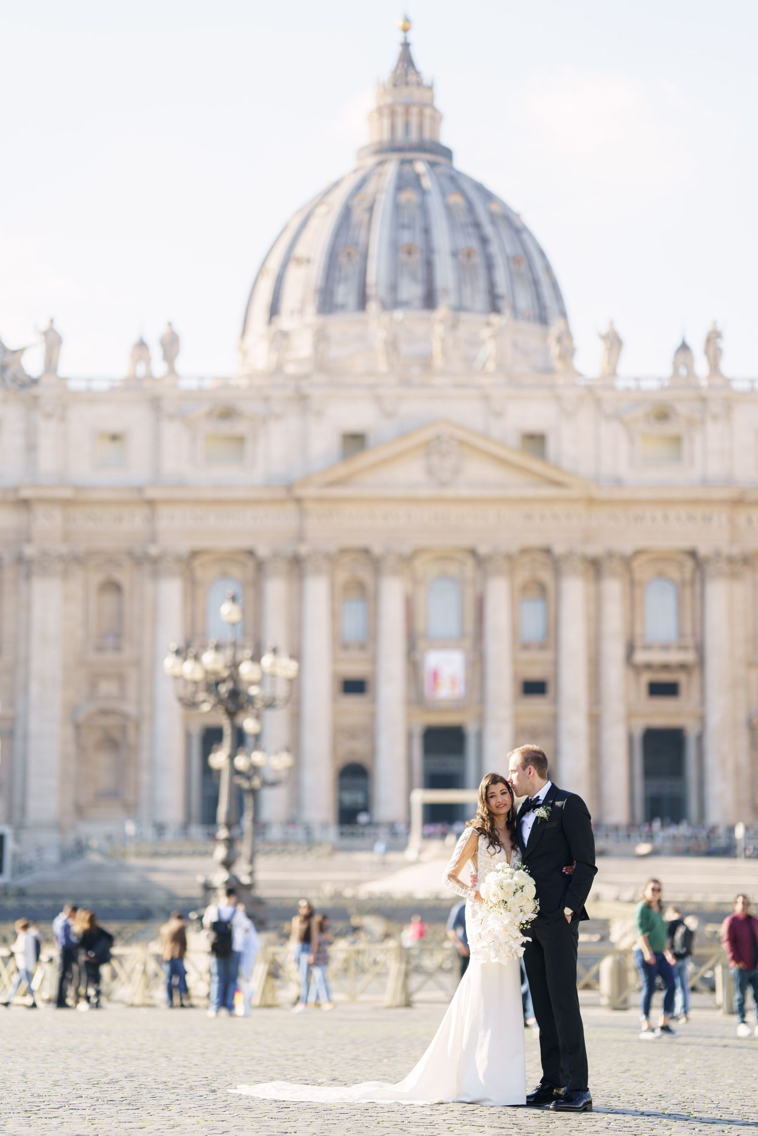 Wedding photography session at St. Peter's Square with the majestic basilica facade and columns in the background.