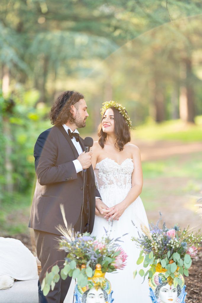 Intimate wedding table setting with colorful wildflower arrangements in an outdoor garden setting.