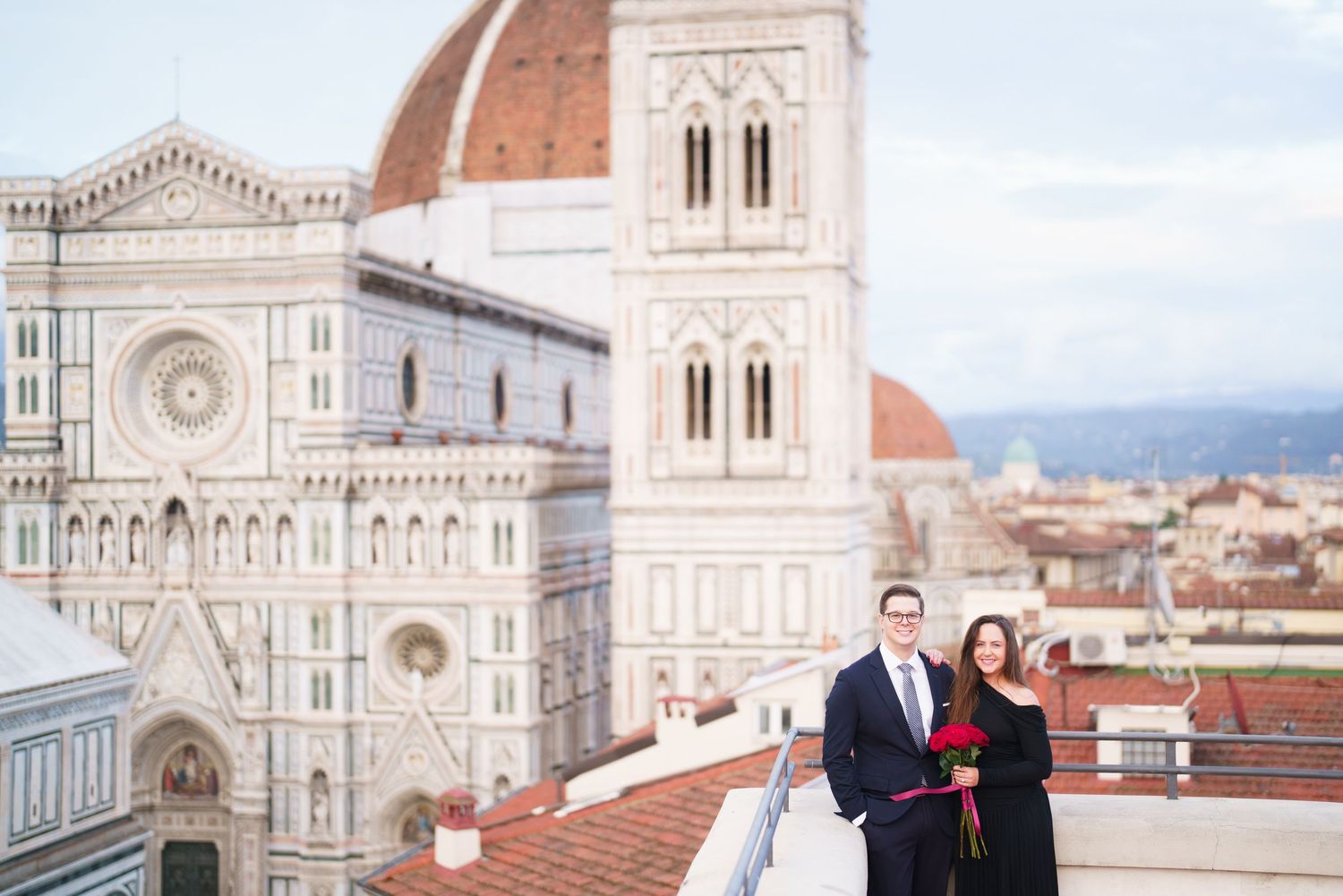 Panoramic view of Florence's historic Duomo cathedral and surrounding terracotta rooftops against a cloudy sky.