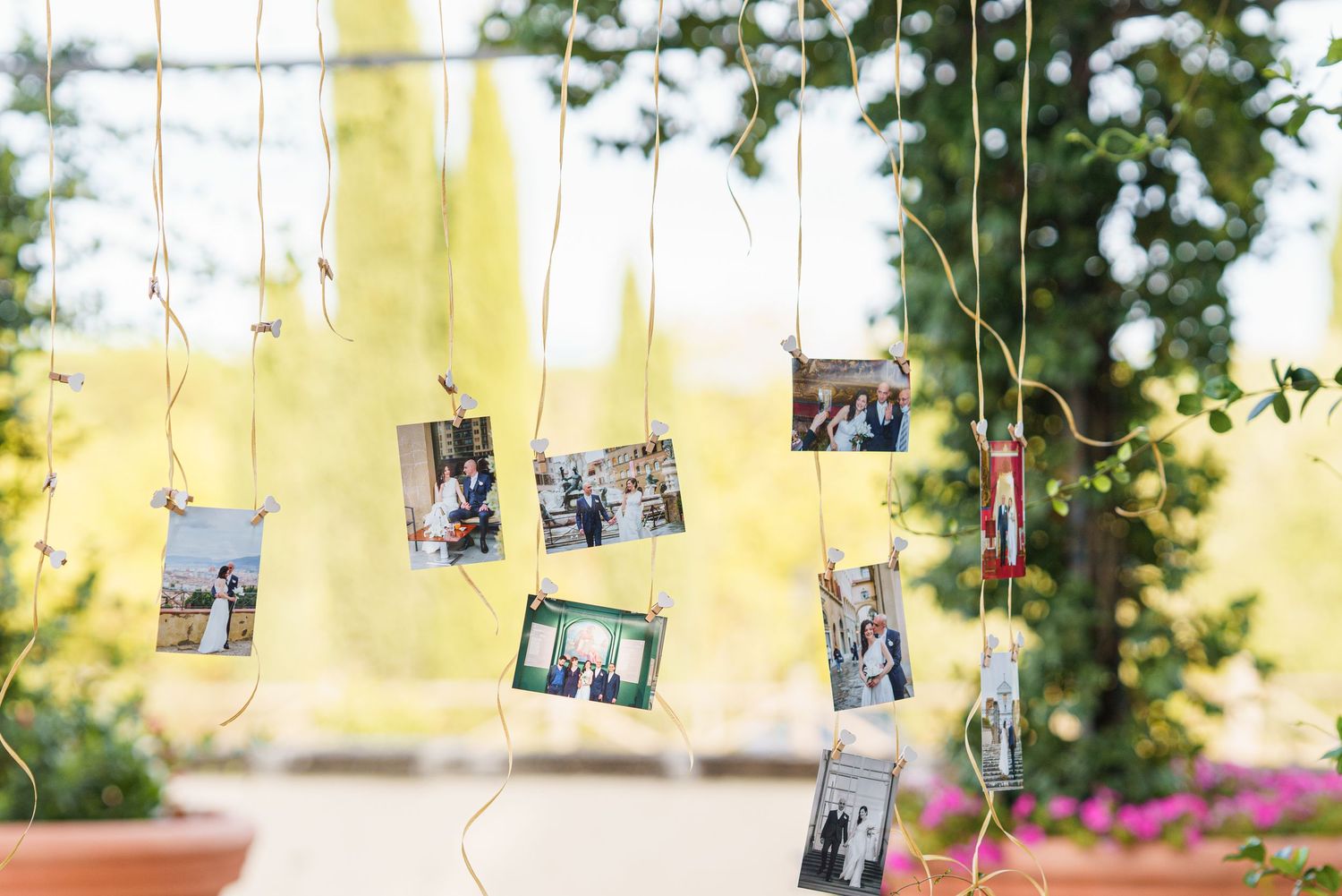Vintage photographs hanging on strings creating a rustic wedding decoration display.