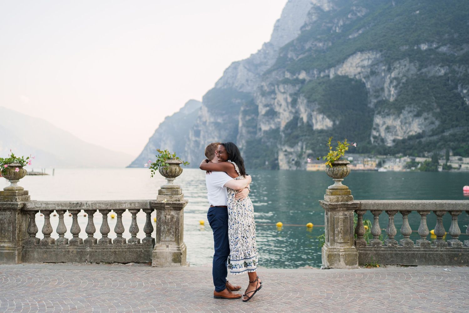 Engaged couple embracing beside Lake Garda during their Riva del Garda proposal session