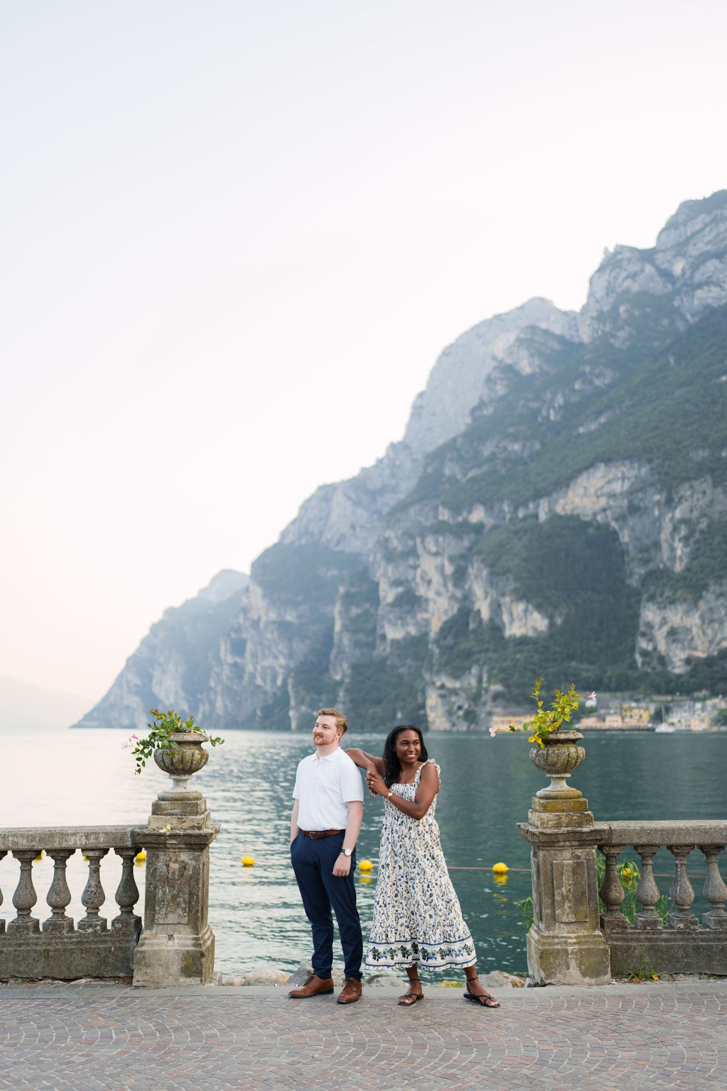 Engaged couple embracing beside Lake Garda during their Riva del Garda proposal session