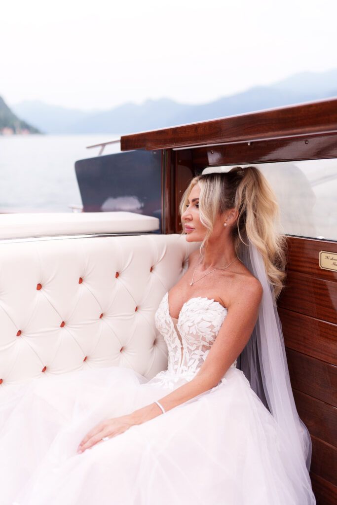 Elegant wedding dress detail shot on luxurious white tufted seating with mountain views.