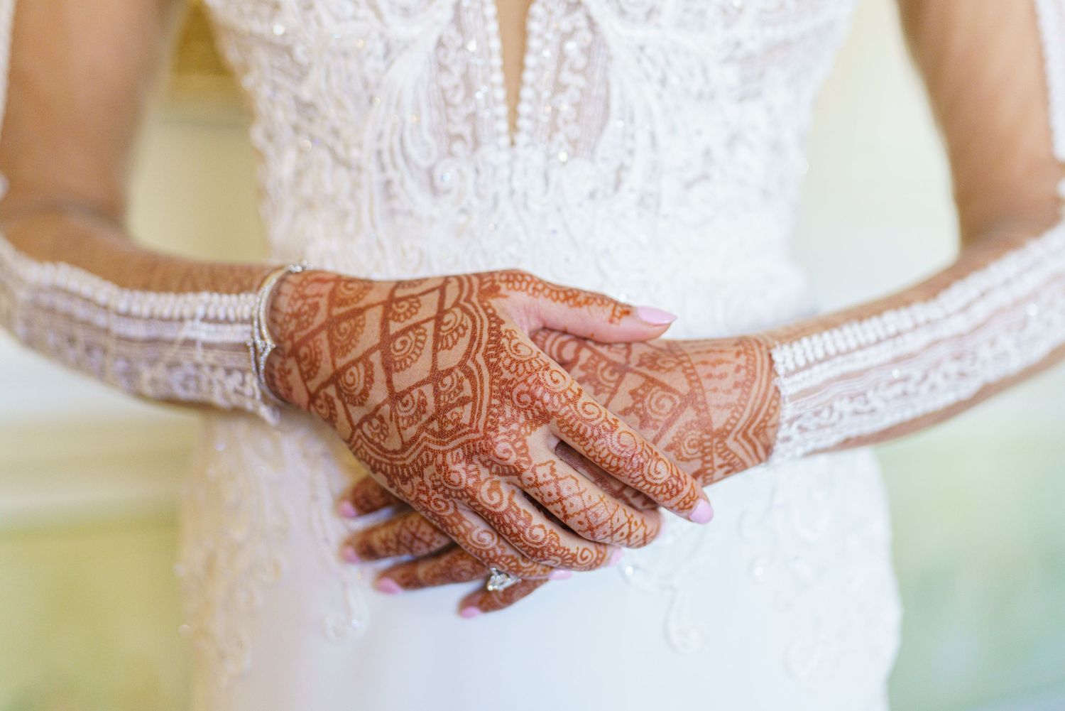 Close-up of intricate lace details and beading on wedding dress bodice.