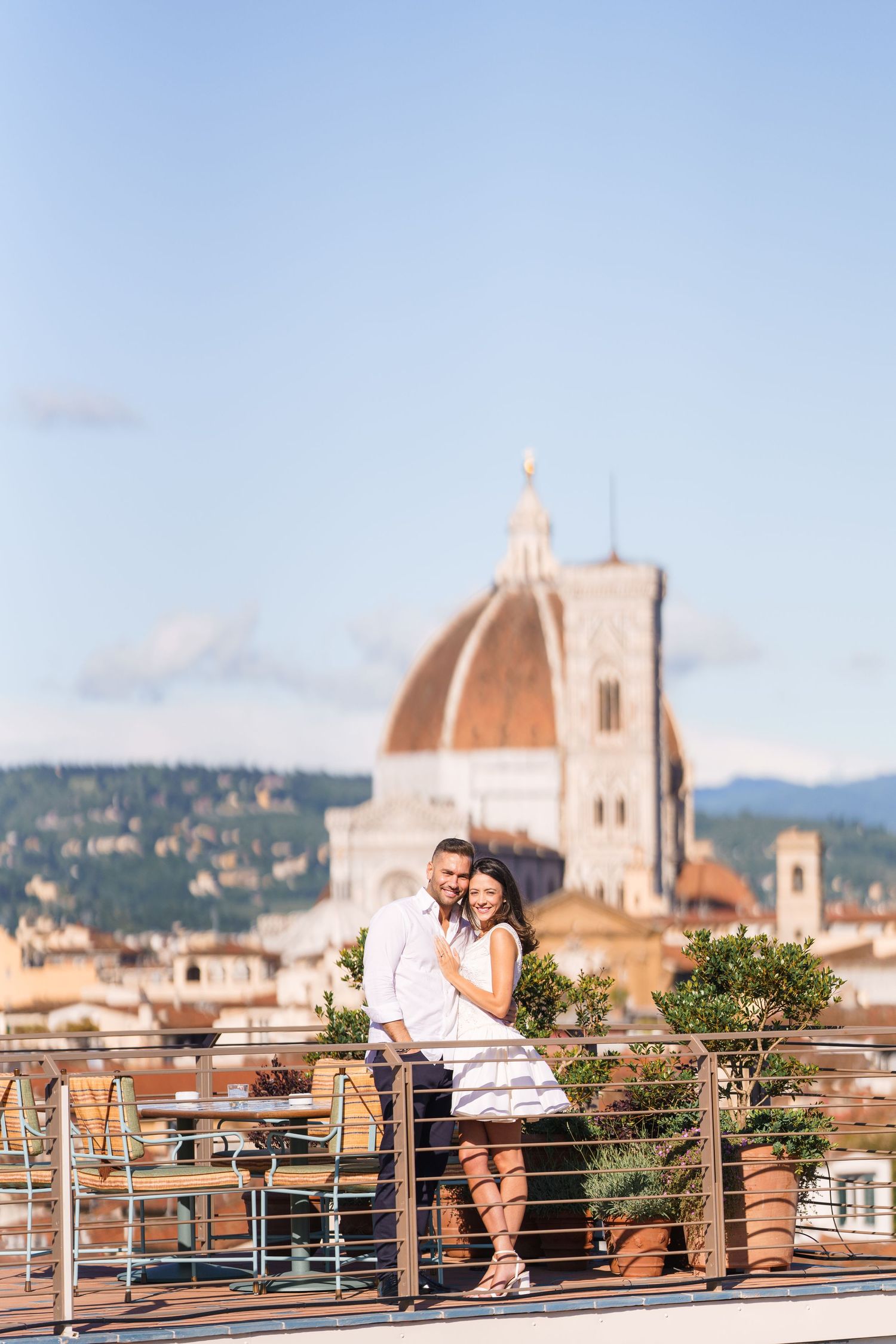 Couple embracing on a scenic rooftop with Florence's famous Duomo cathedral in the background.