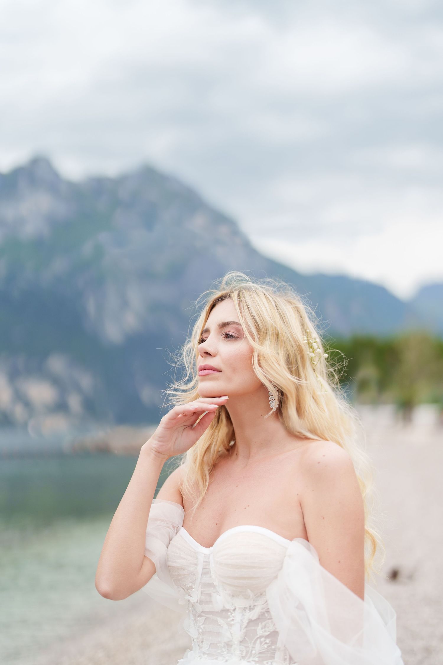 A white dress flows in the breeze against a mountainous backdrop.