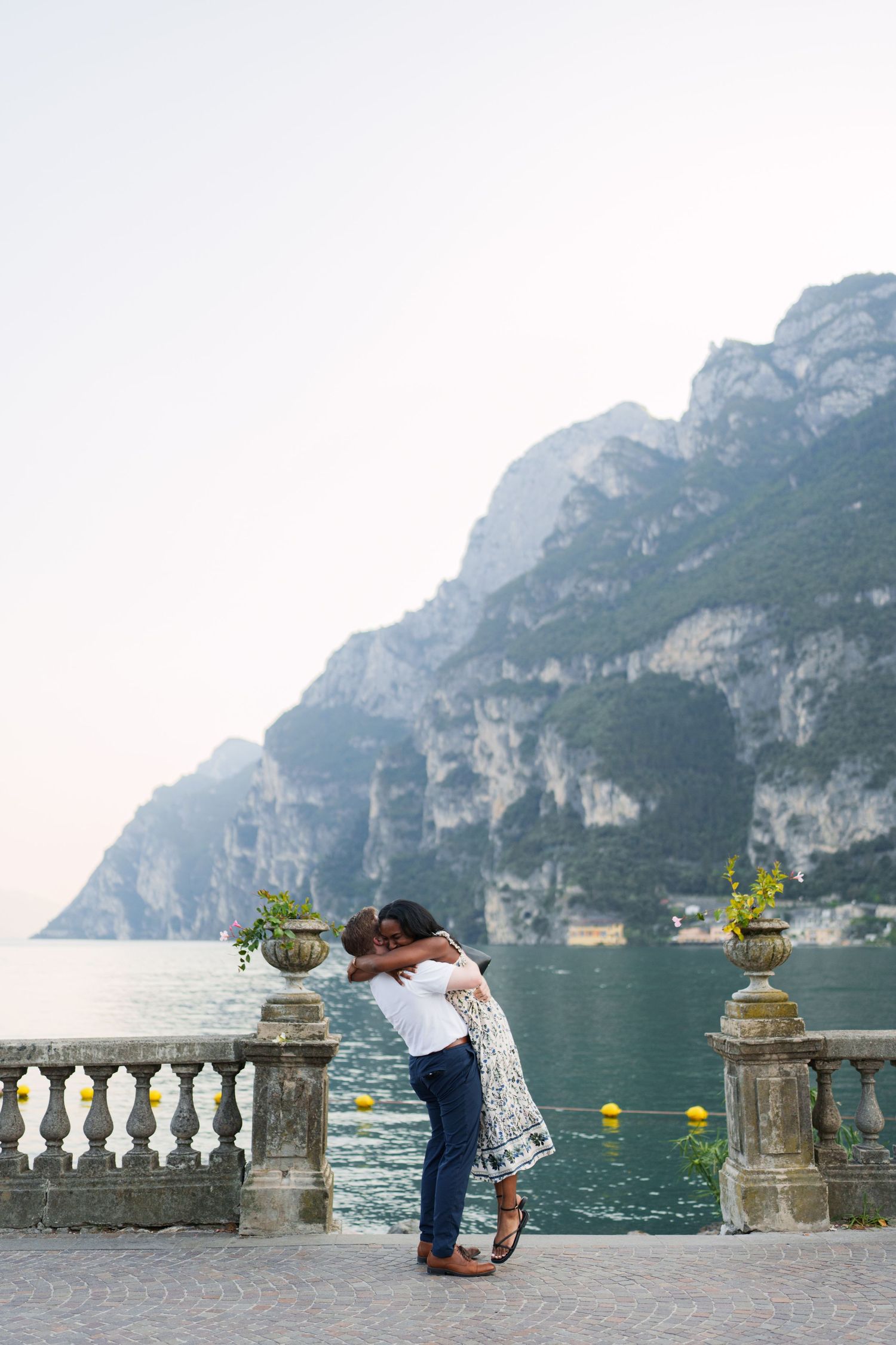 Couple walking together along the waterfront after their proposal in Riva del Garda