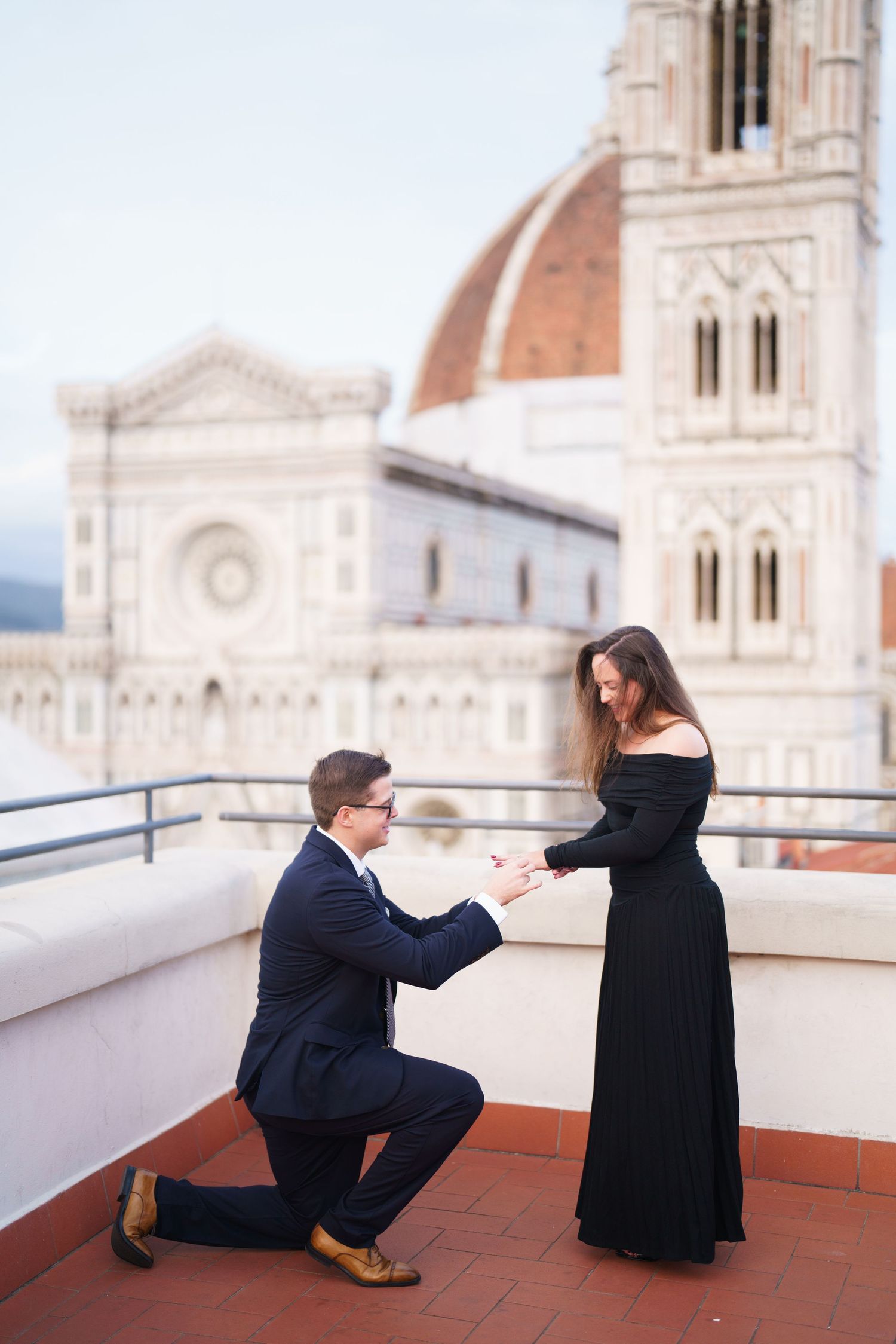 A romantic proposal moment on a rooftop terrace overlooking the iconic Duomo cathedral in Florence, Italy.