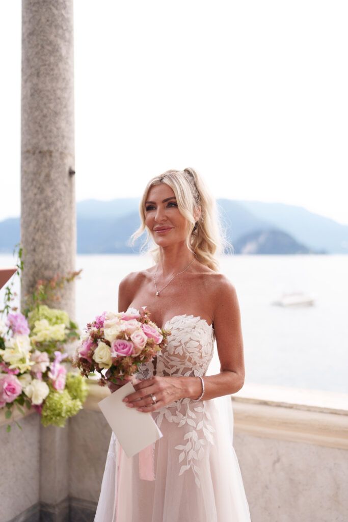 Wedding celebration on an elegant terrace with classical columns and coastal views.