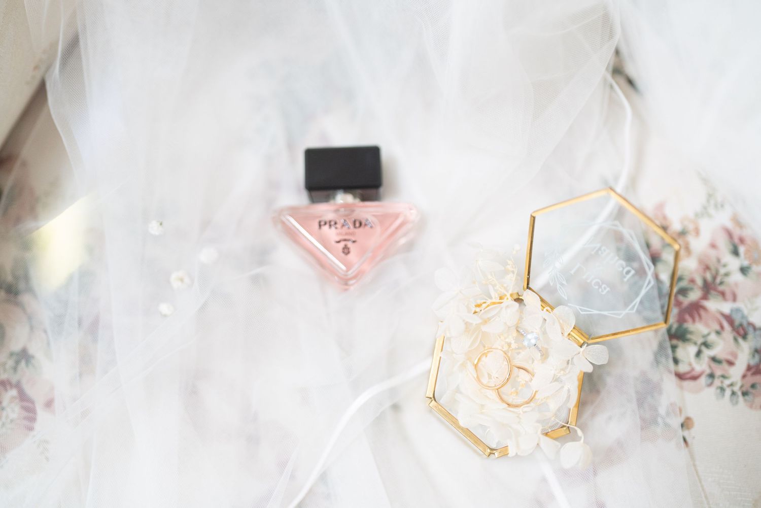Soft focus close-up of white tulle fabric with rose gold decorative elements.