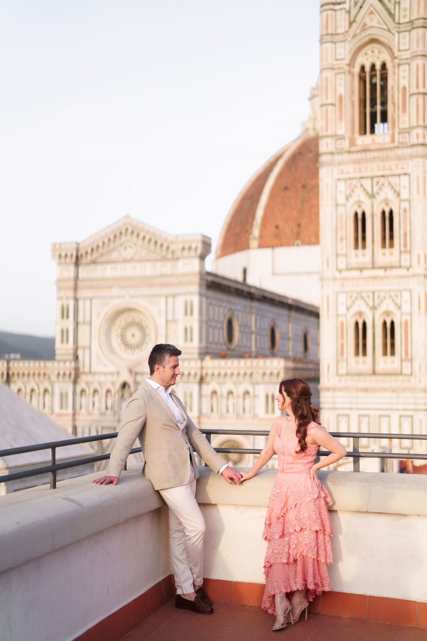A couple shares a romantic moment on a rooftop terrace overlooking the Florence Cathedral in Italy.