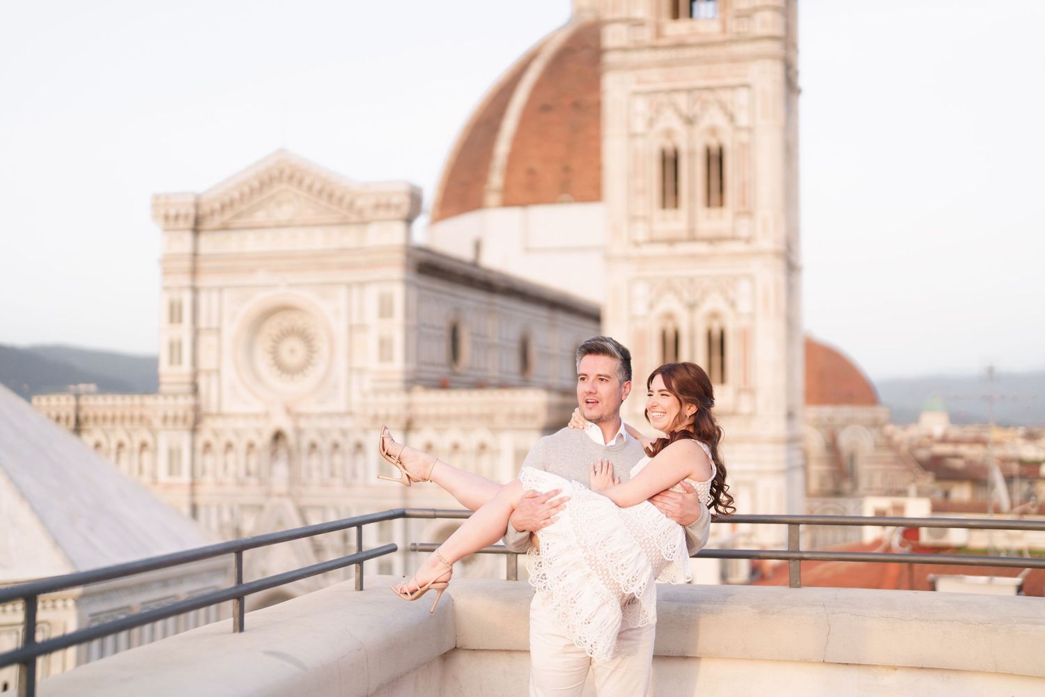 A romantic couple embraces during a sunrise photoshoot at Florence Cathedral in Italy.