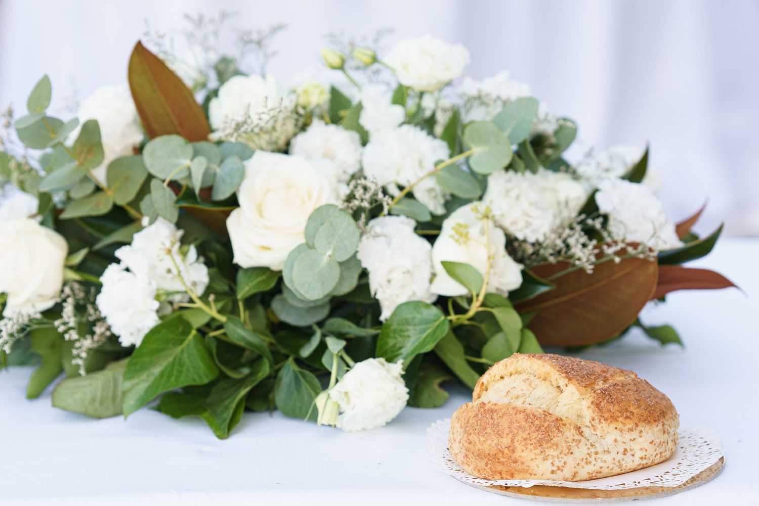 Elegant white roses and greenery arranged in a decorative display.