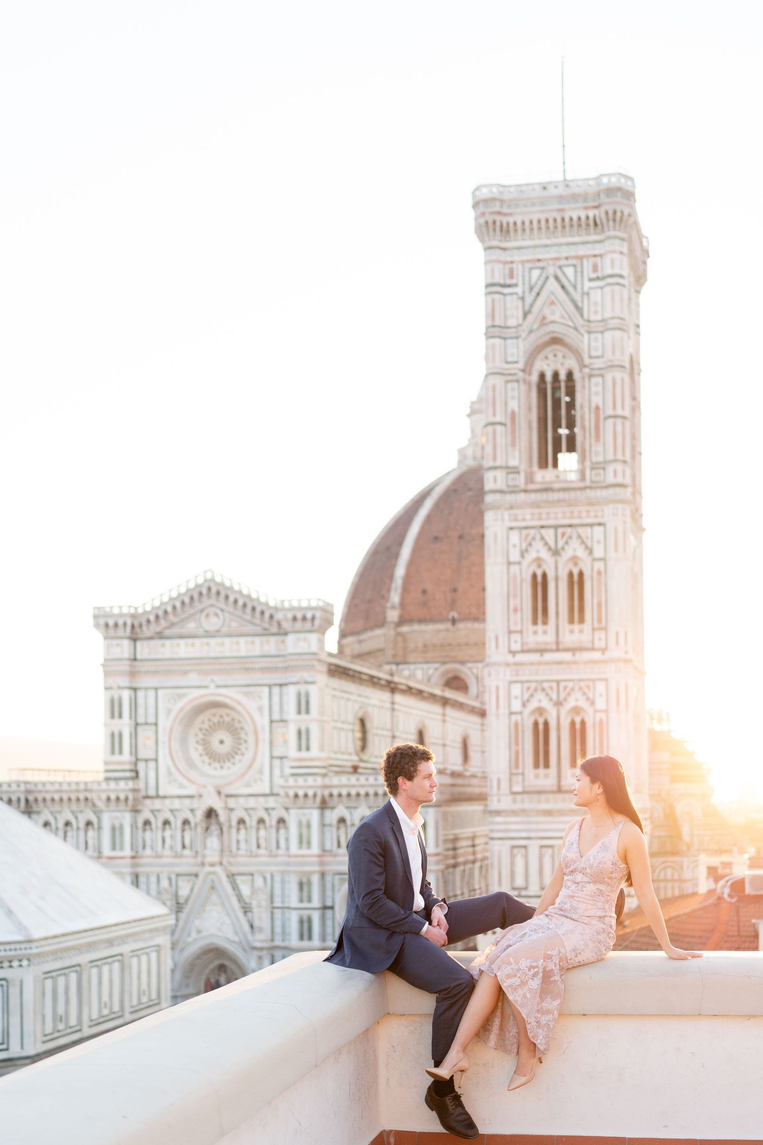 Romantic couple poses at sunset against Florence Cathedral's iconic dome and architecture in Italy.