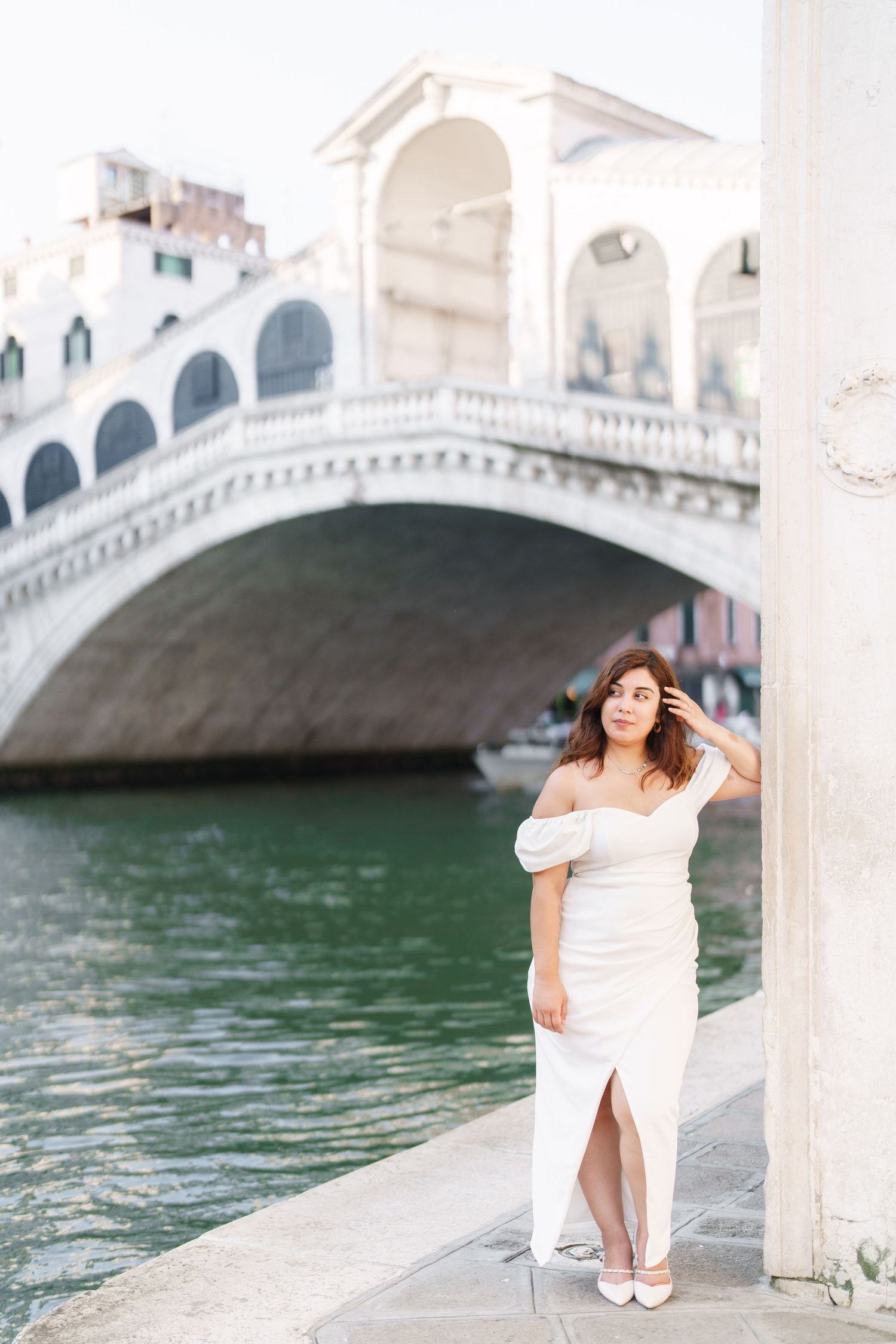 Romantic photoshoot in Venice with the iconic Rialto Bridge and green canal waters in the background.