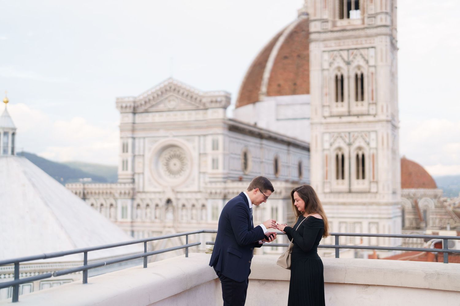 A couple shares a romantic moment outside the historic Florence Cathedral in Italy during their engagement photoshoot.